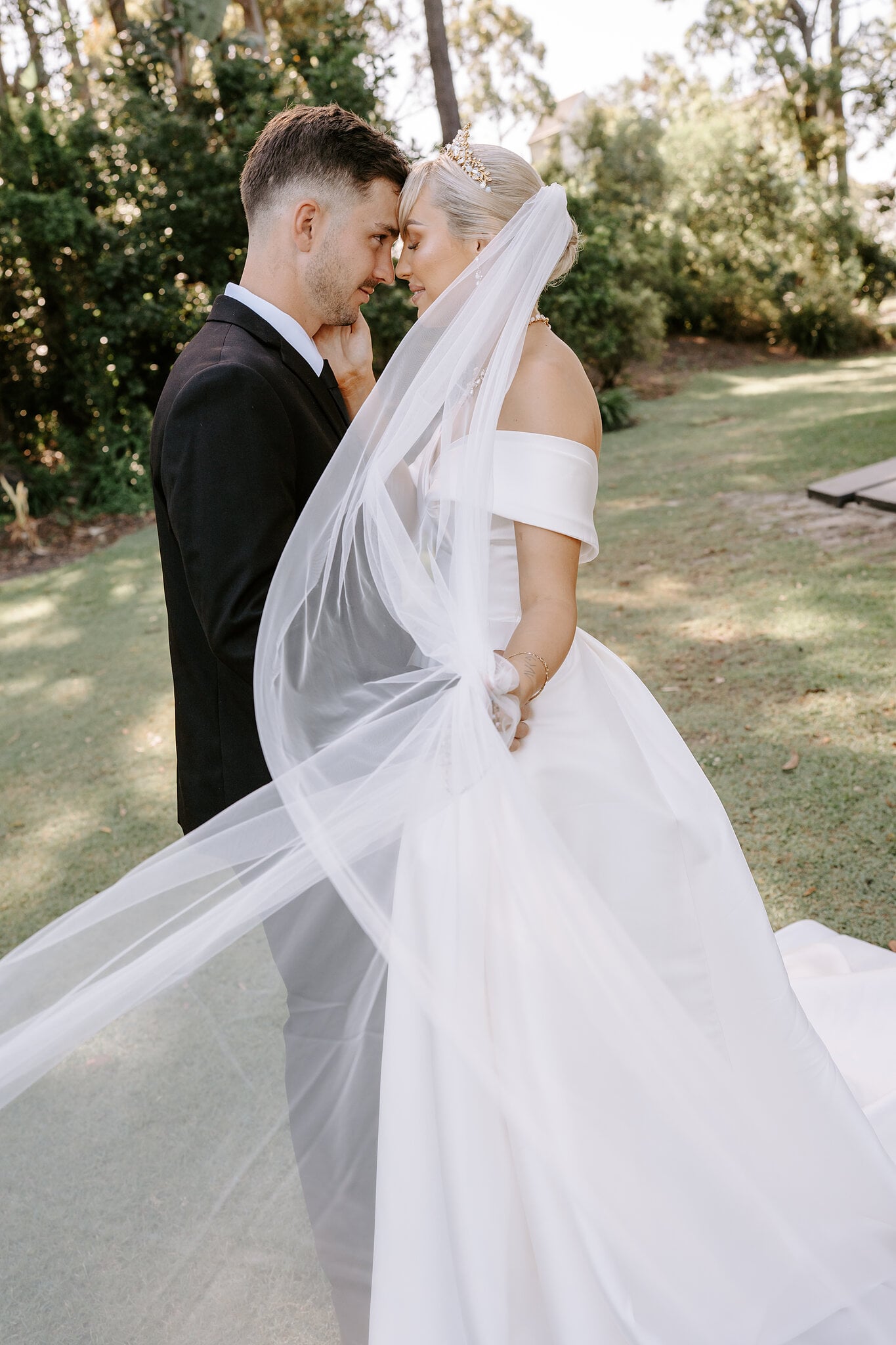 Foreheads together on the lawn, Ashley’s veil drifting across Lane’s shoulder.