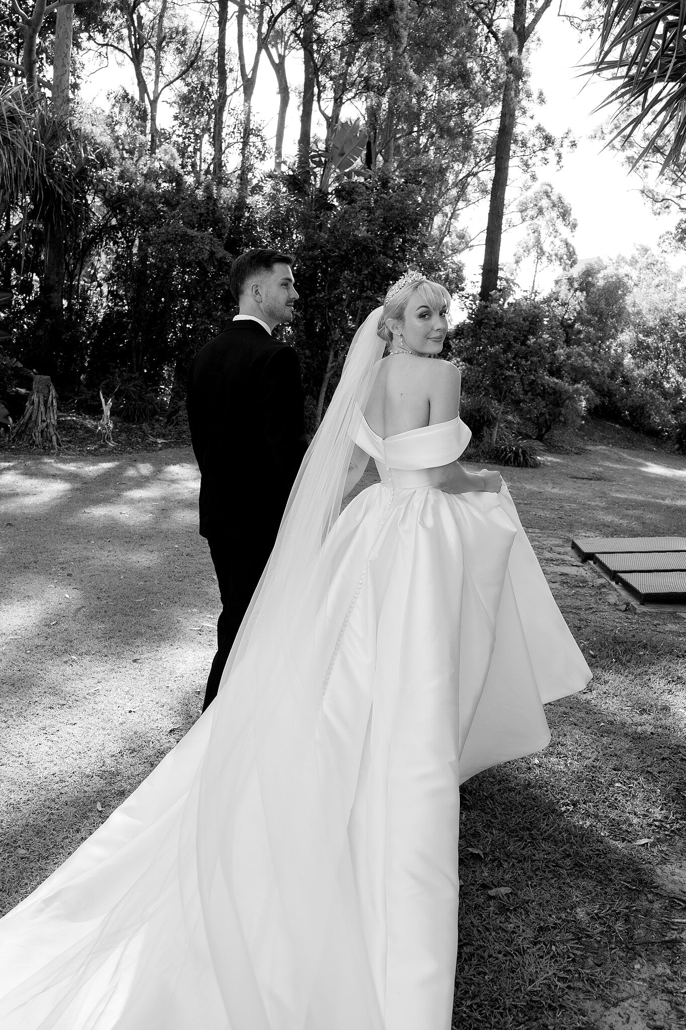 Ashley looks back over her shoulder as she and Lane walk through the gardens at InterContinental Sanctuary Cove.