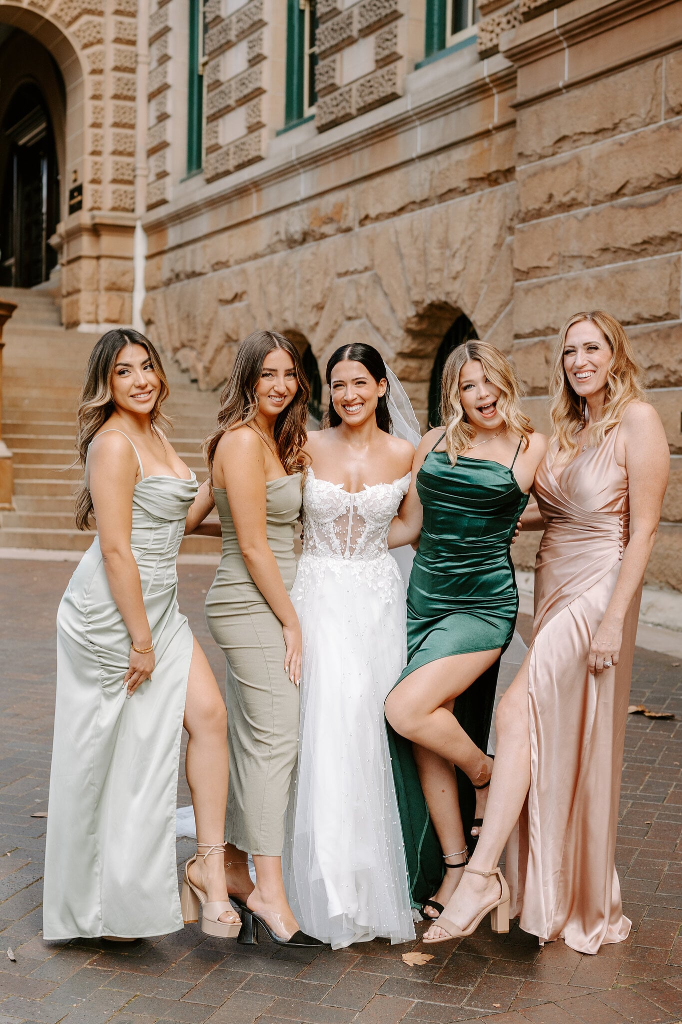 Alexa and her bridesmaids laugh together in front of the sandstone arches at InterContinental Sydney.