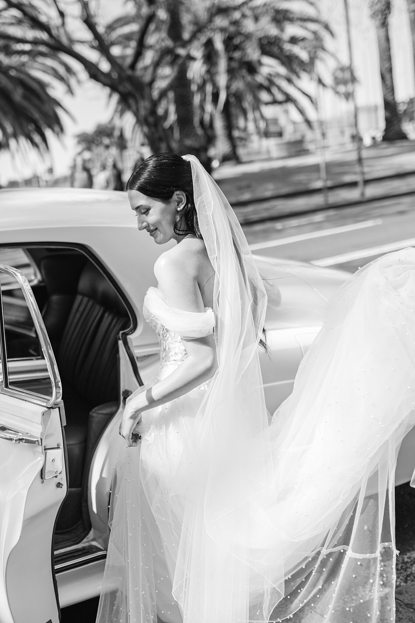 Alexa steps into the vintage Rolls-Royce, her veil spilling across the back seat.