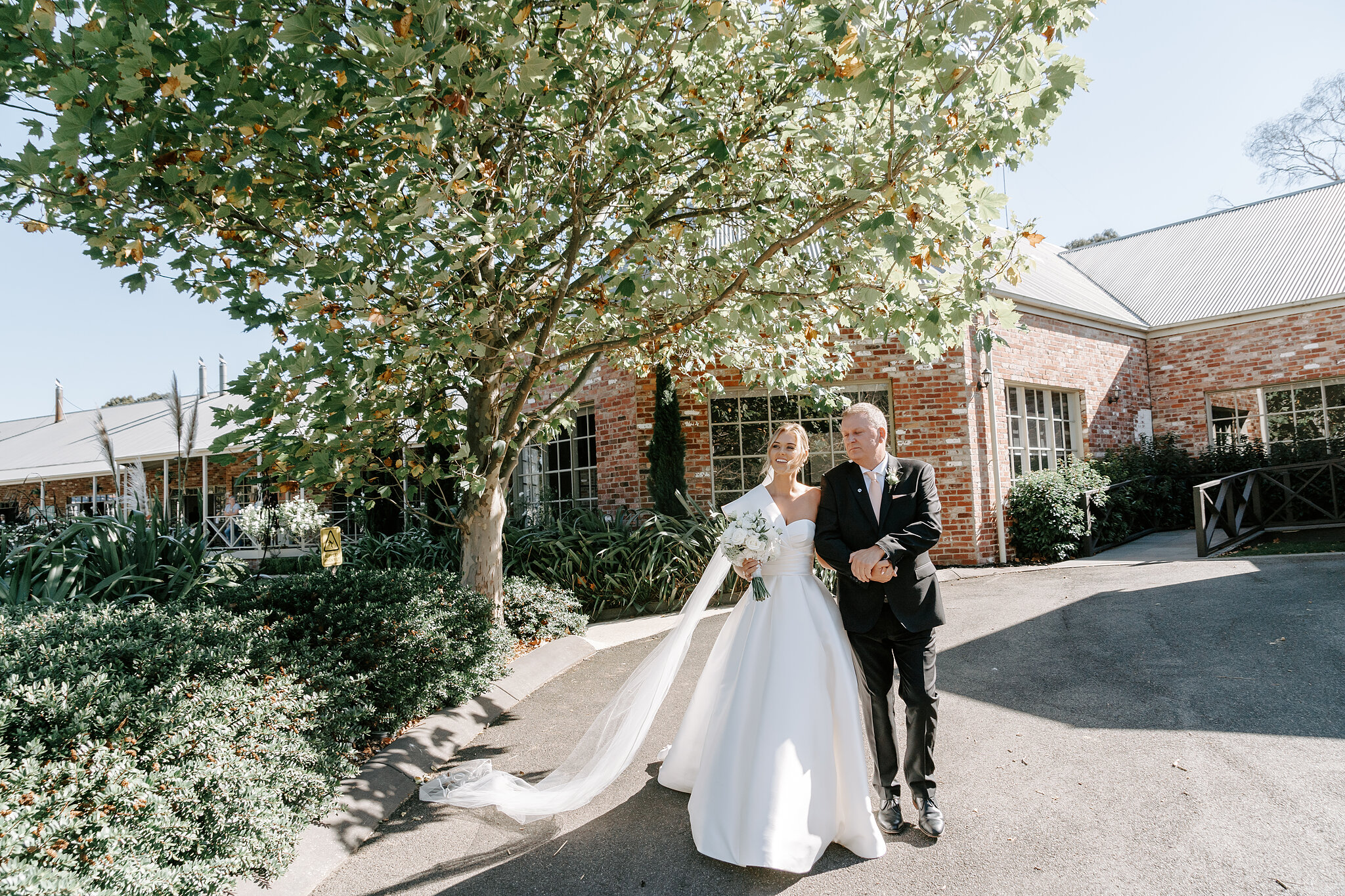 Georgie walks to her garden ceremony on the arm of a loved one at Mercure Ballarat.