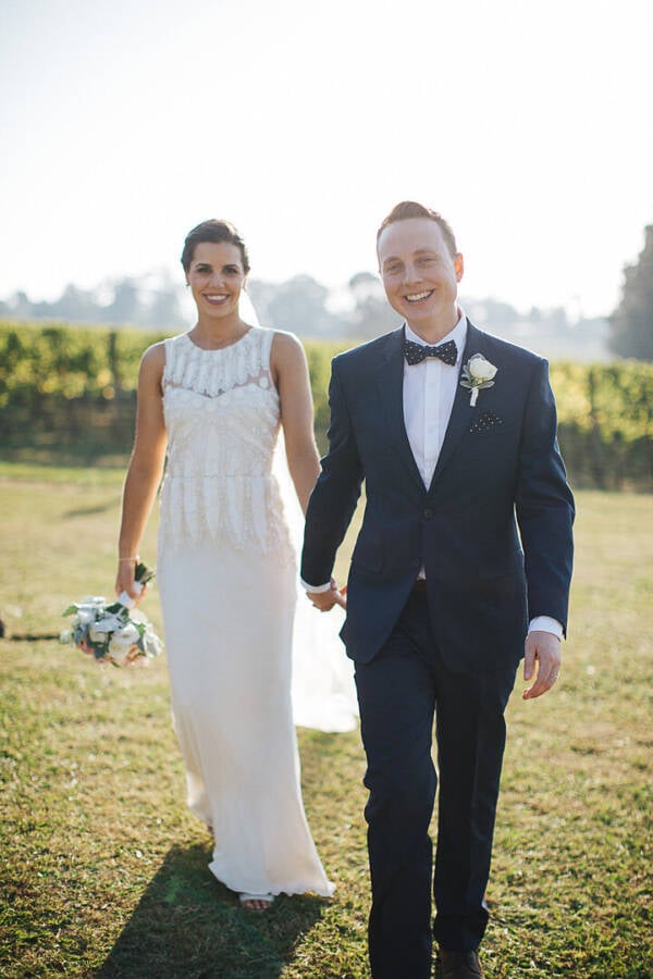 Kate and Wes walk beside the vines at Paynes Rise Wines Paynes Rise Wines Wedding Photo Yarra Valley