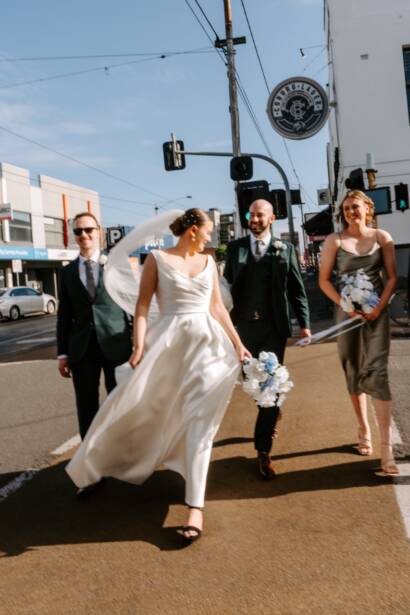 Crossing the road with their bridal party outside the Post Office Hotel, Coburg