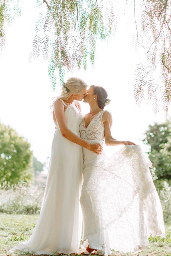 Ashlee and Kate kiss beneath the trees at Riverstone Estate Riverstone Estate Wedding Photo Yarra Valley