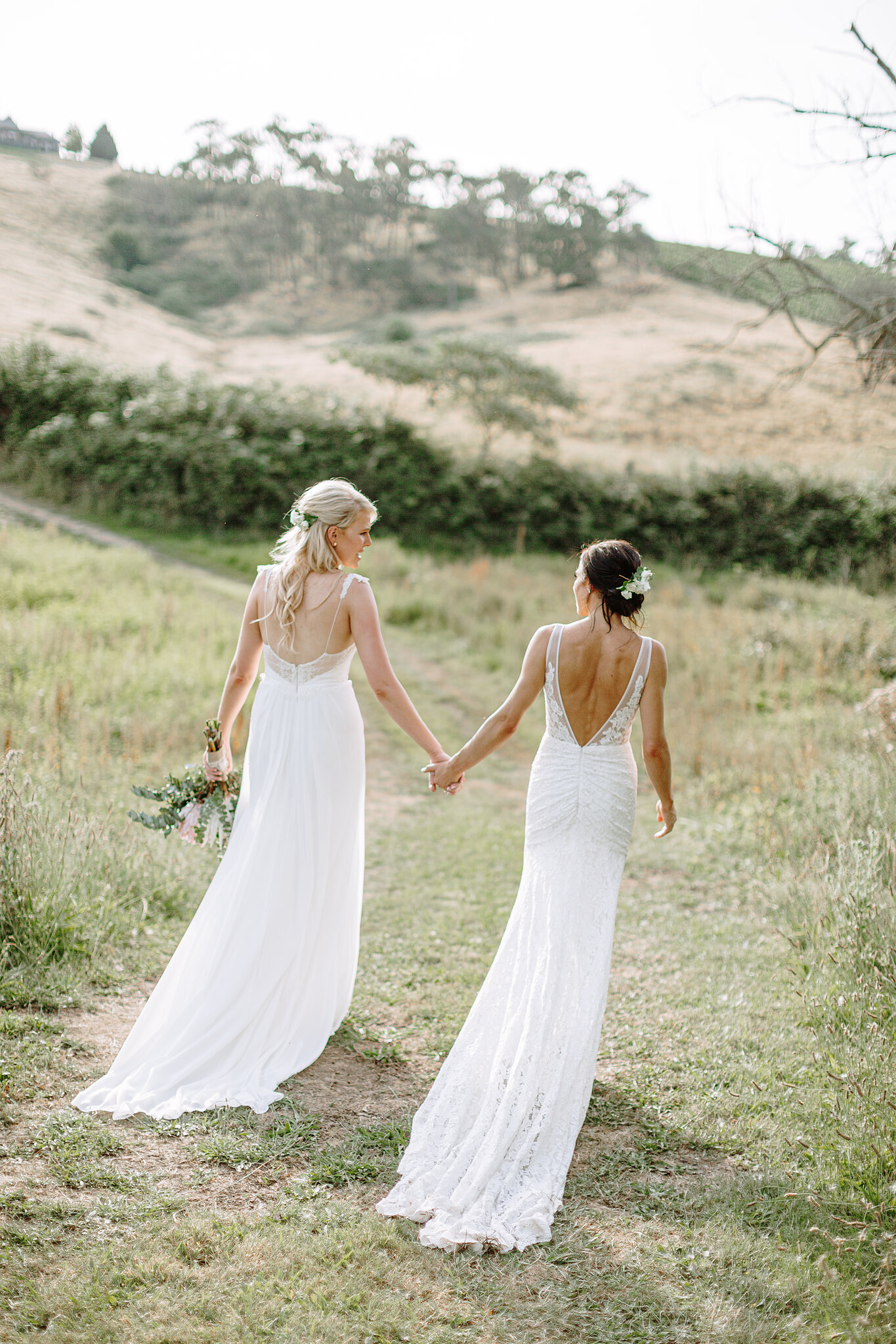 Ashlee and Kate walk through the paddock at Riverstone Estate Riverstone Estate Wedding Photo Yarra Valley