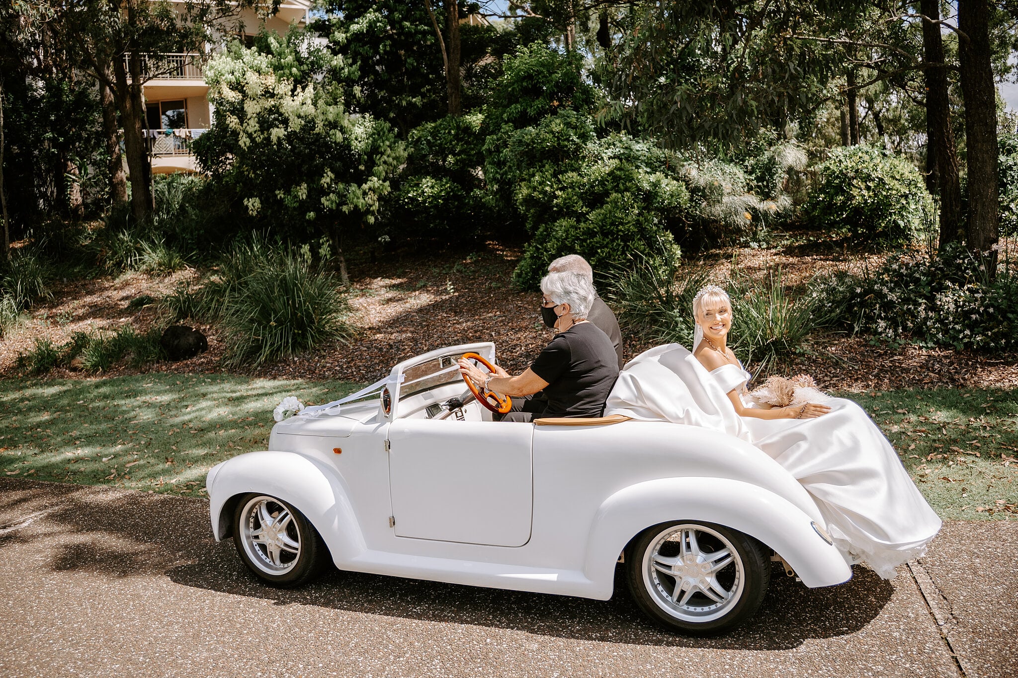 Ashley rides to the chapel through the gardens of InterContinental Sanctuary Cove in the open white buggy.