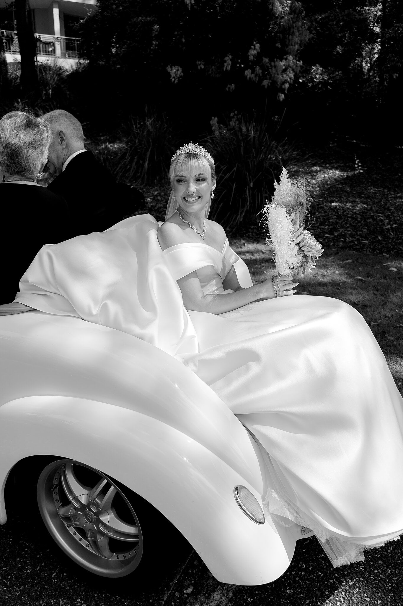 Ashley beams from the back seat of the buggy, bouquet in hand, on her way to her vows.