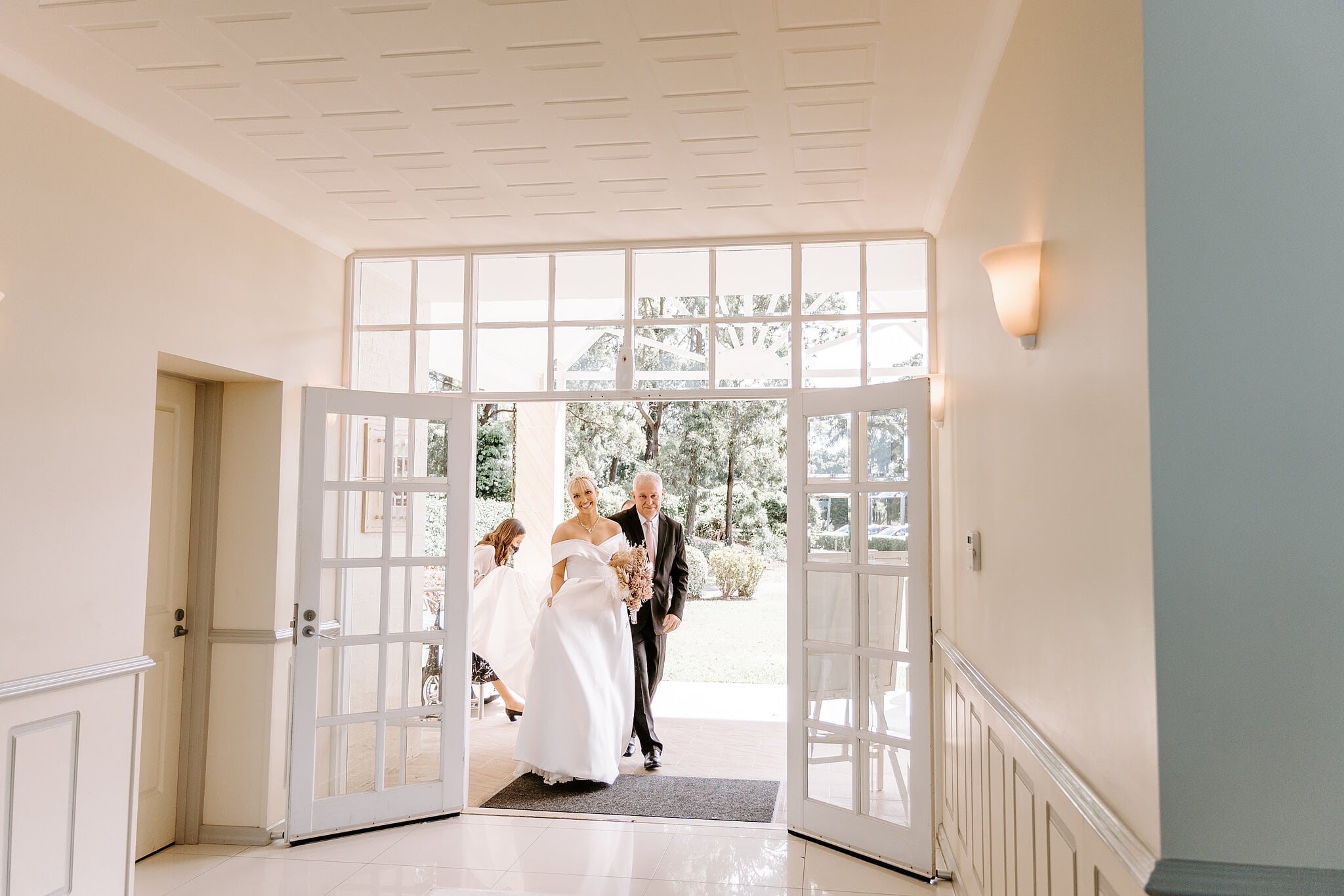 Ashley steps through the chapel doors on her dad’s arm.