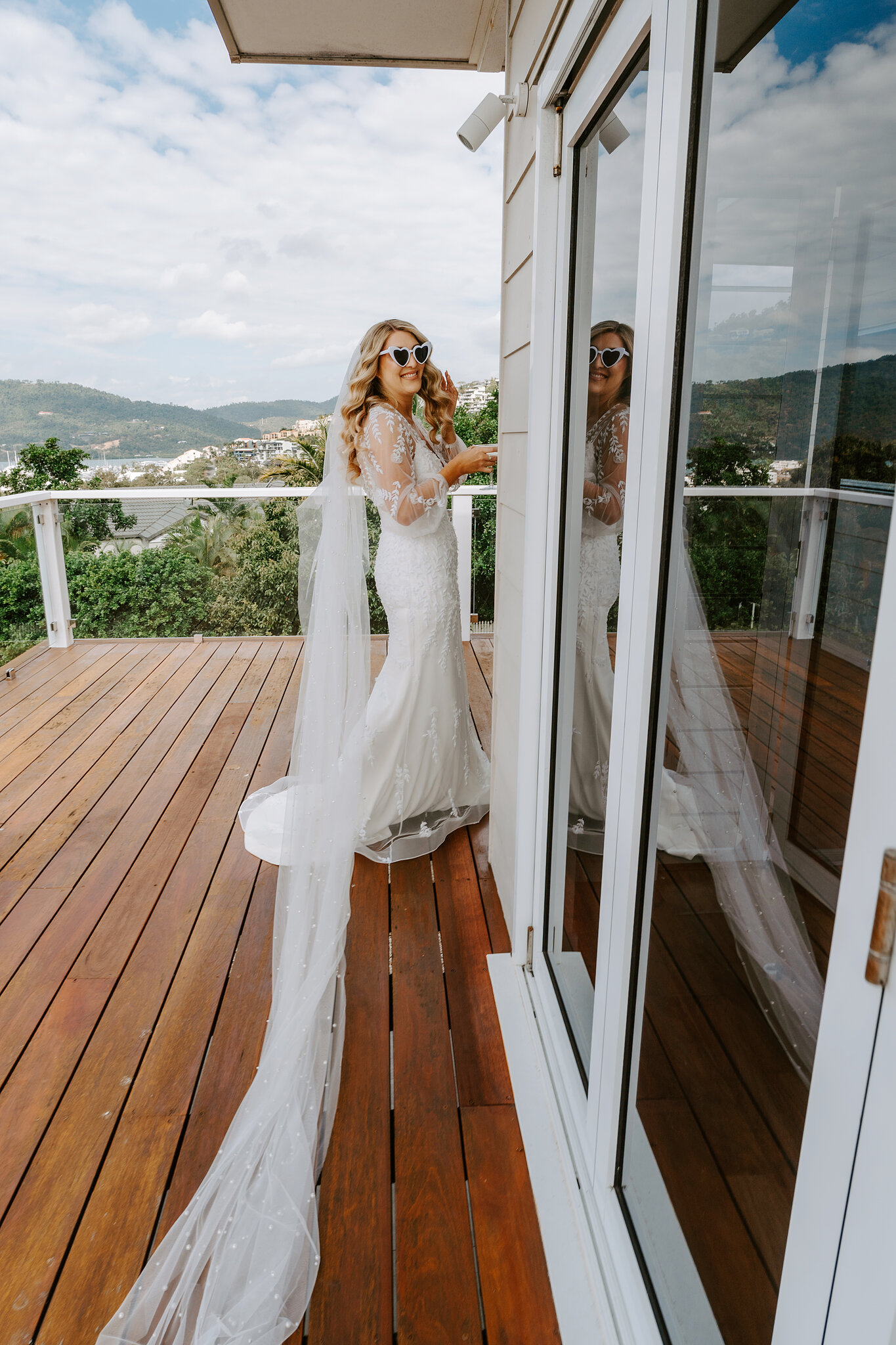 Anna in sunglasses, lace gown and veil on the deck, ready to go.