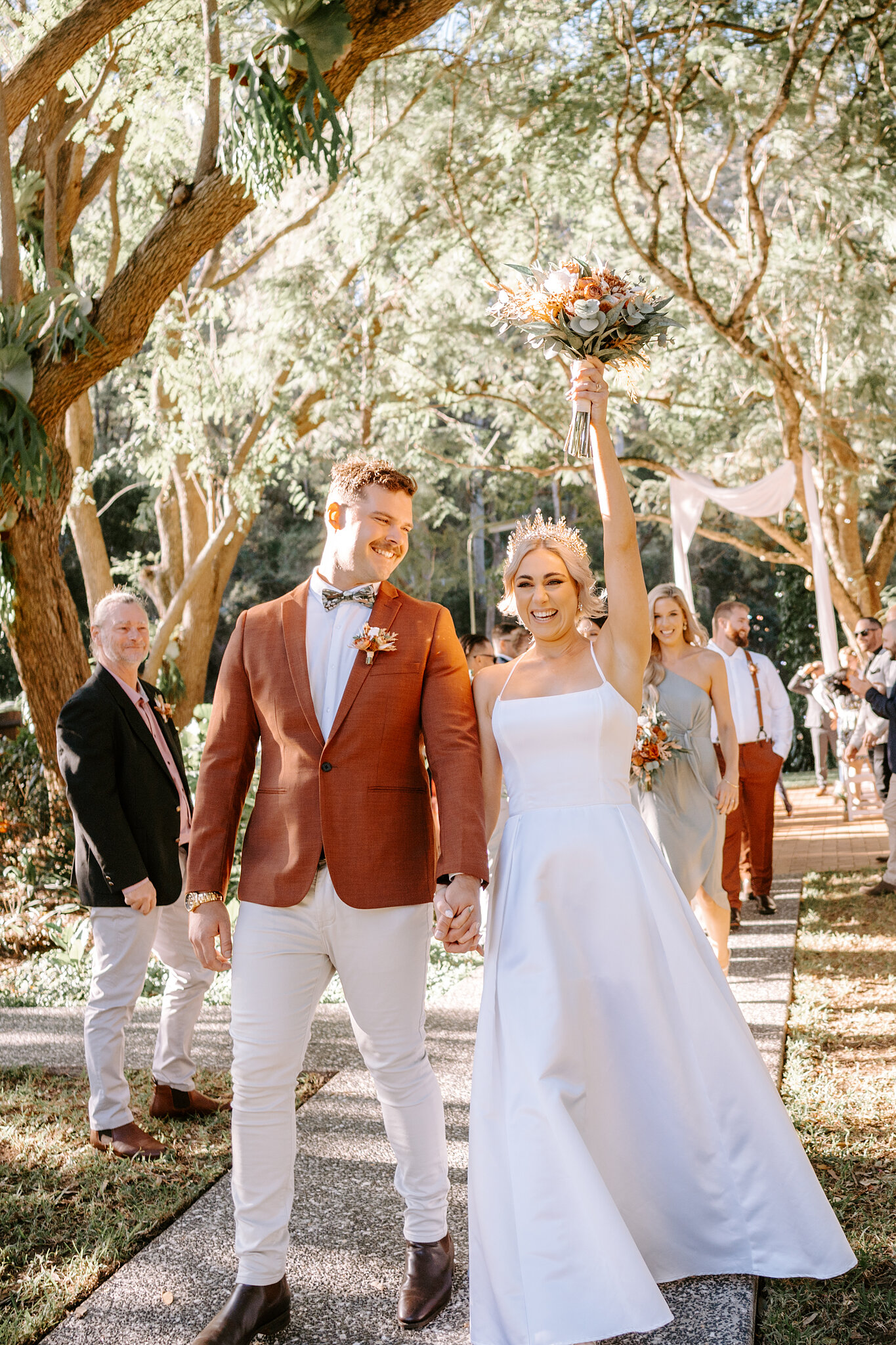 Amanda throws her bouquet in the air as she and Patrick walk back down the path as newlyweds.