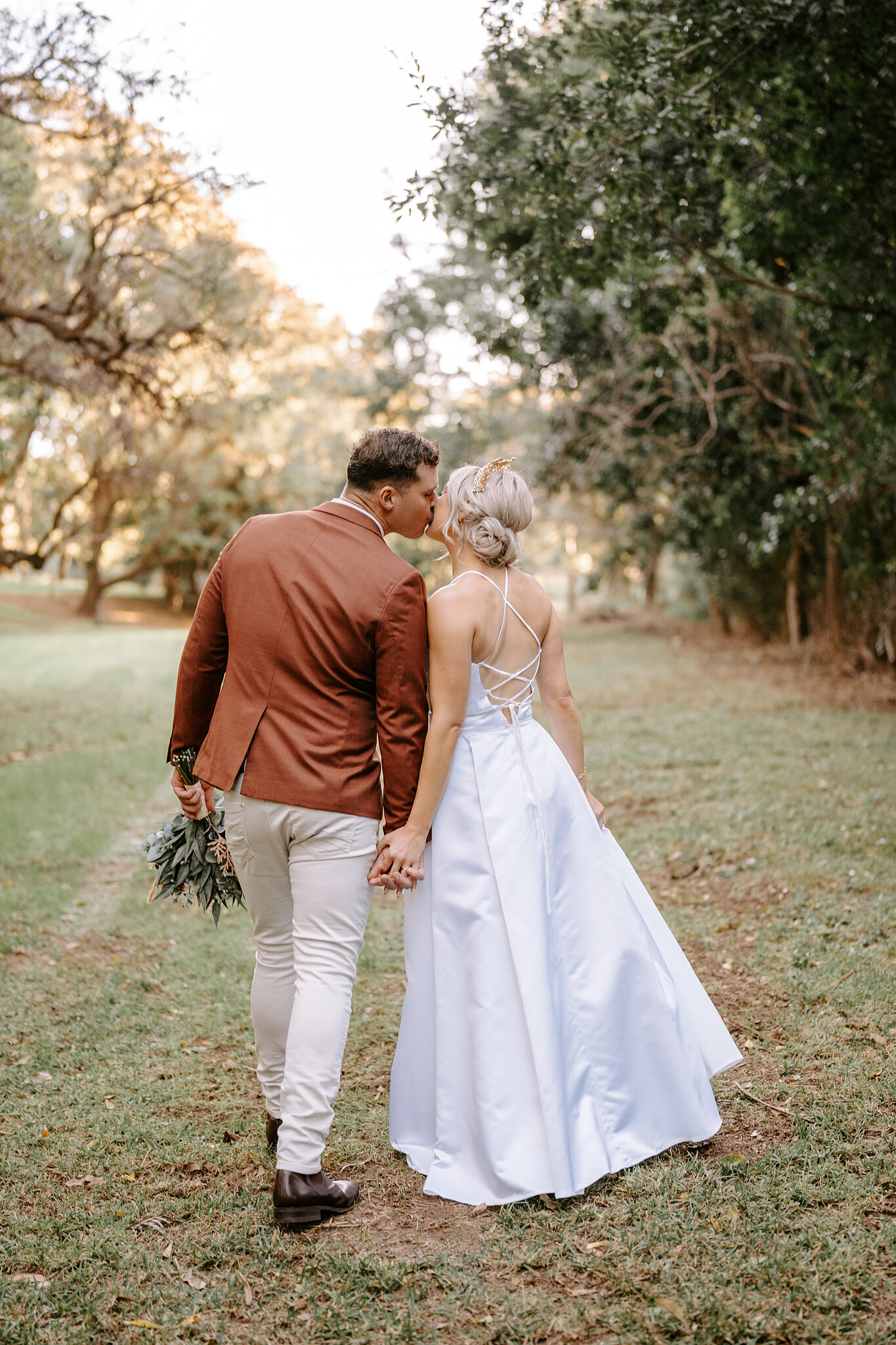 Patrick kisses Amanda as they wander off along a grassy track under the trees, her lace-up gown trailing.