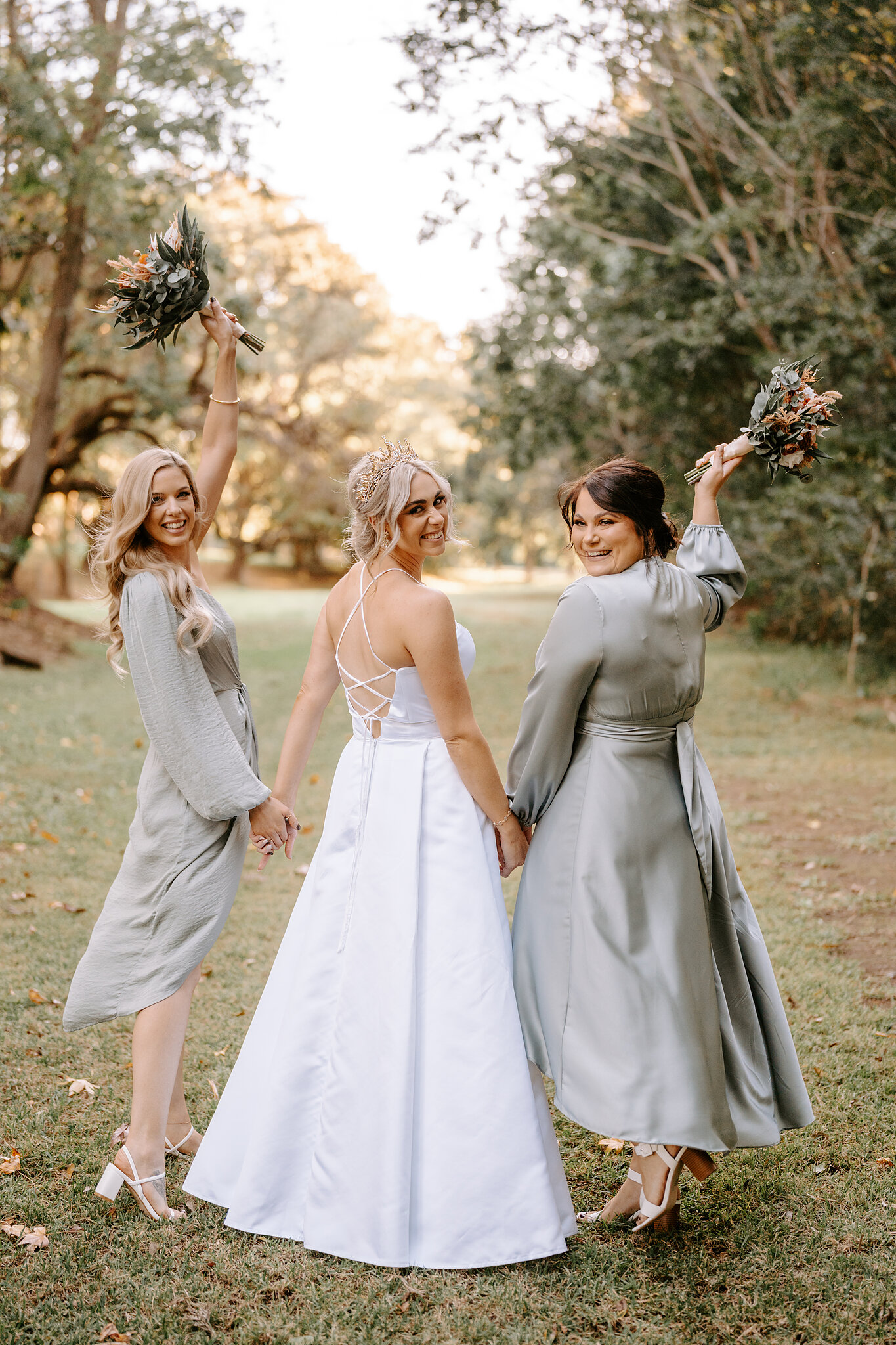 Amanda and her bridesmaids look back over their shoulders, two bouquets thrown in the air.