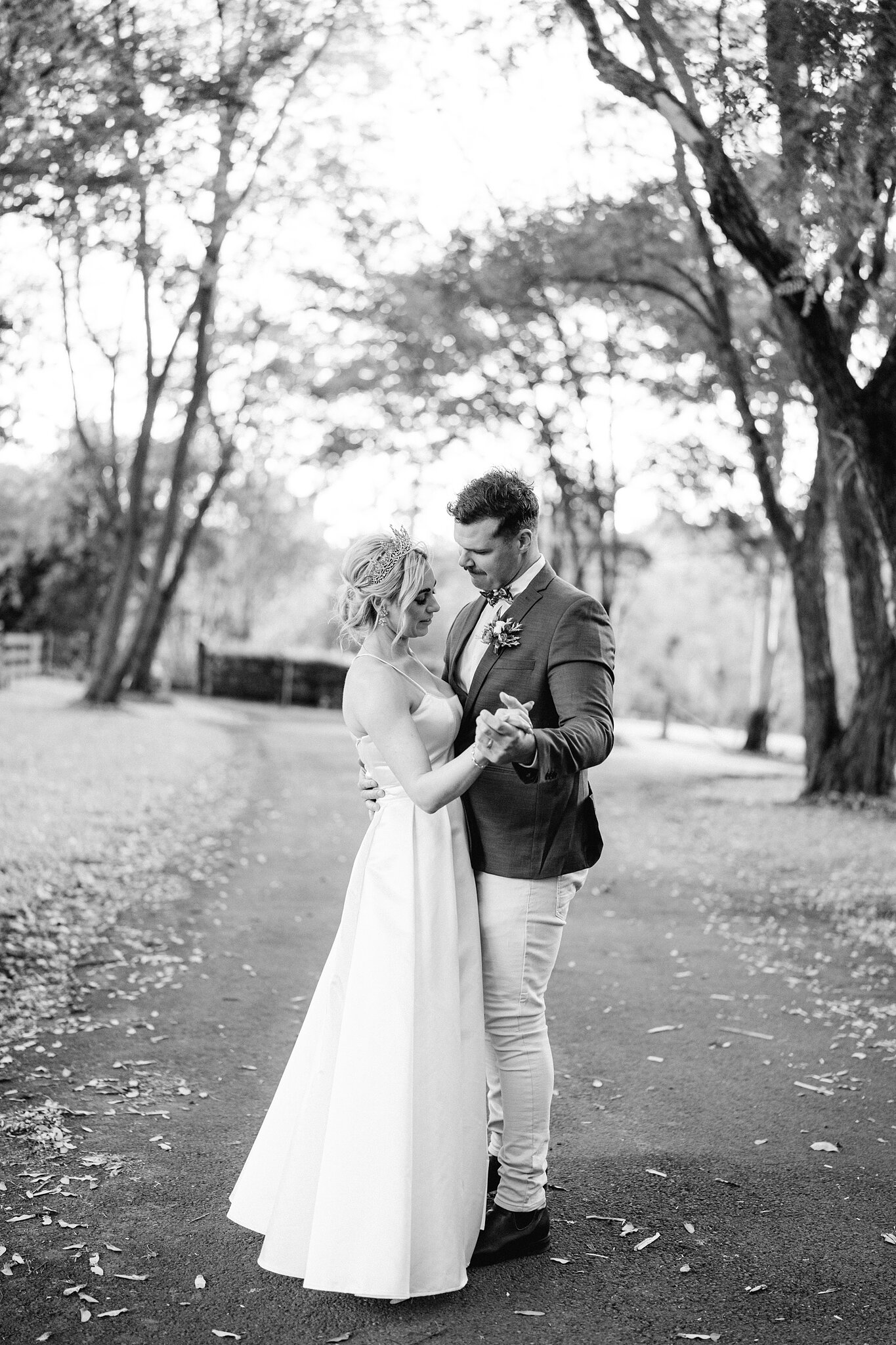 Amanda and Patrick slow-dance on the tree-lined driveway at Bundaleer.