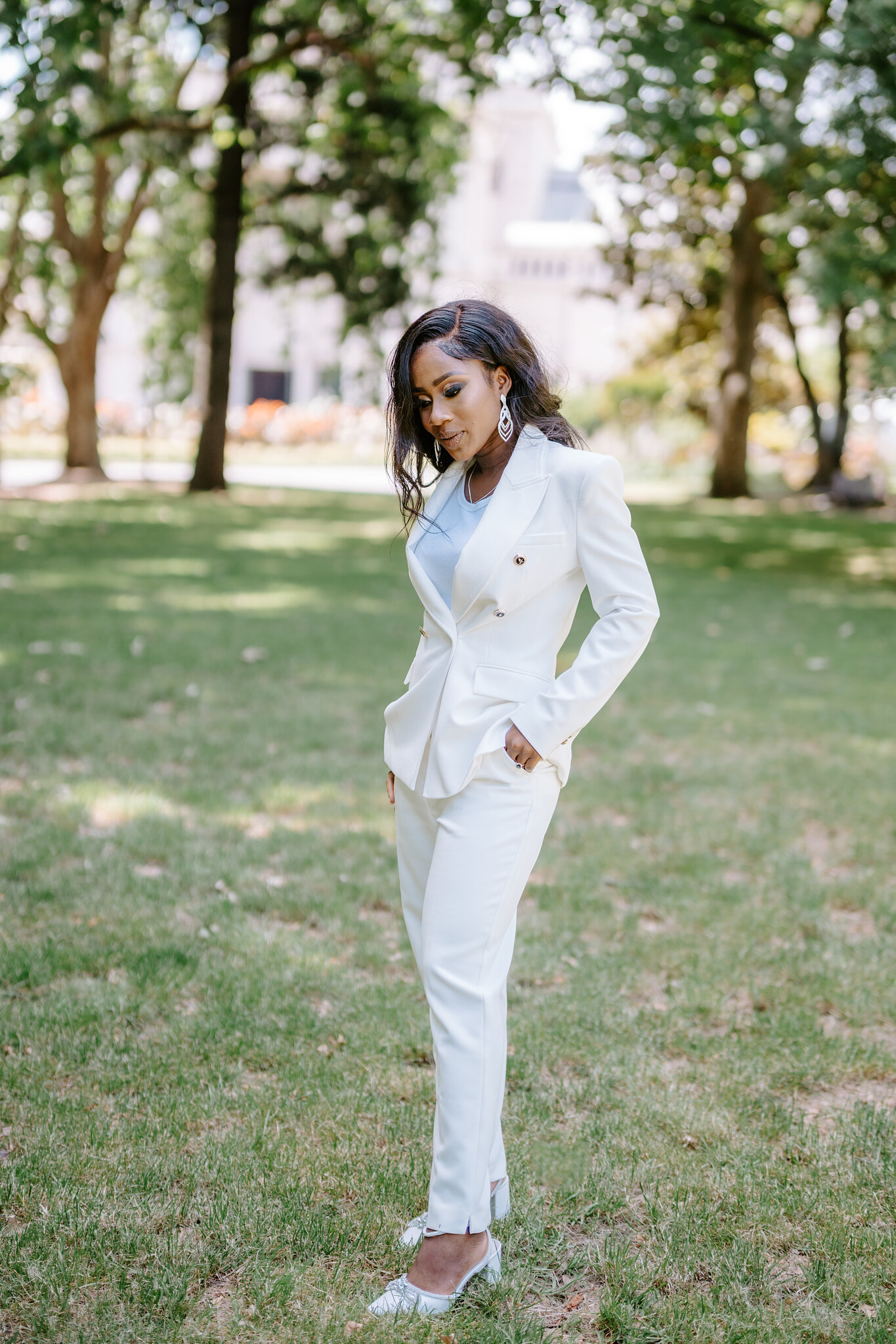 Pearl stands alone in her white suit and sparkly heels on the Carlton Gardens lawn.