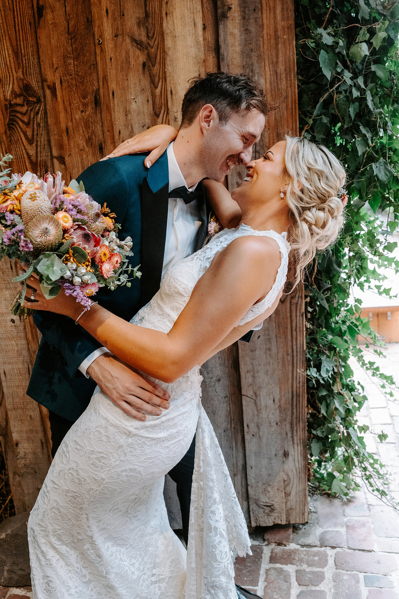 George dips Emma for a kiss against the old timber barn doors.