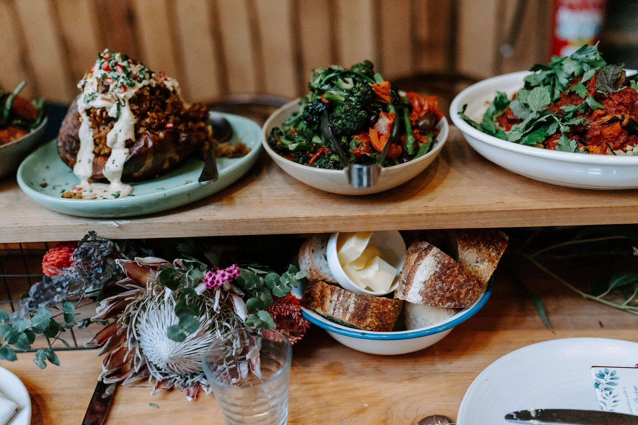 Share plates of roast vegetables, greens and bread on the reception tables.