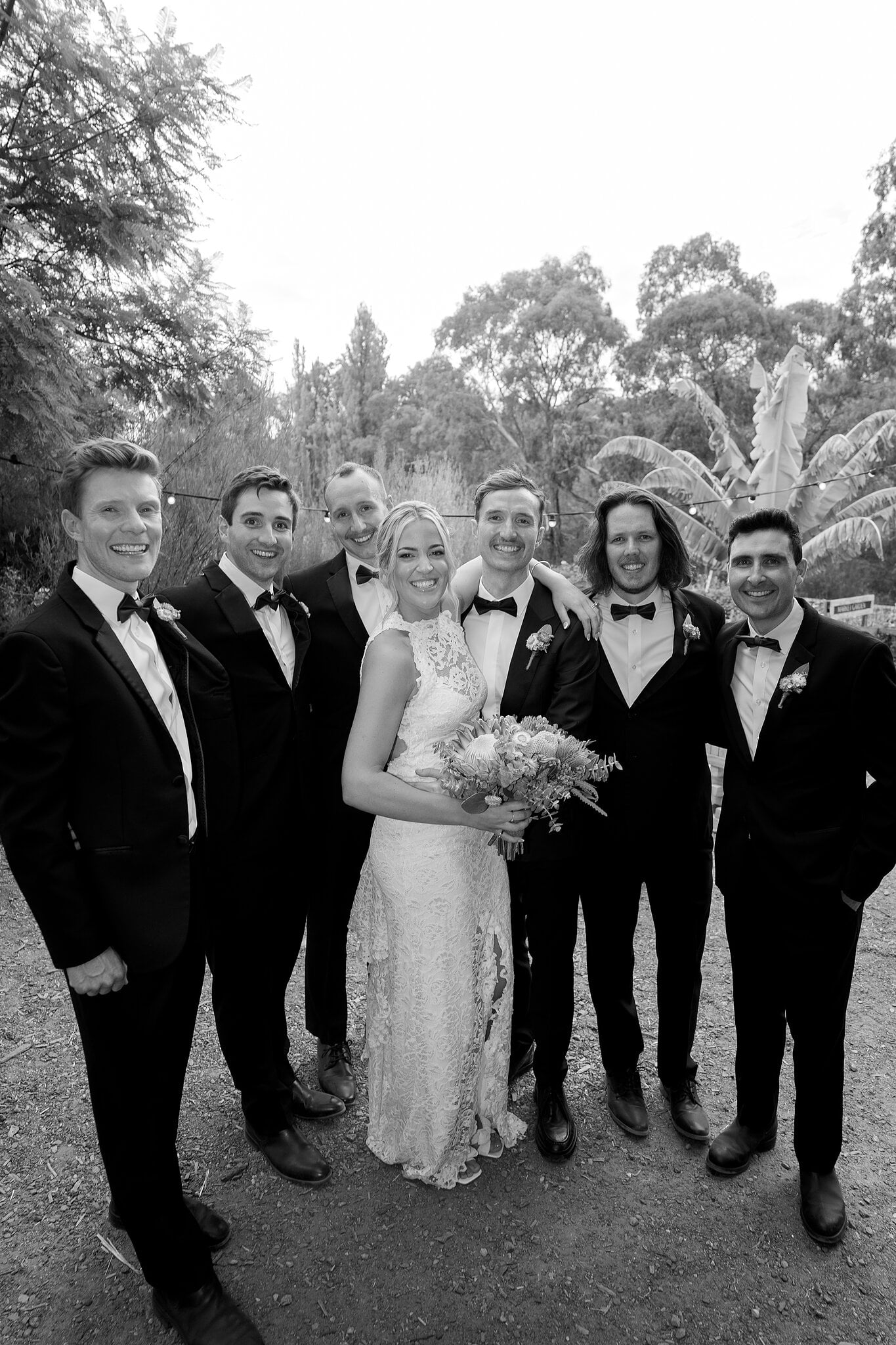 Emma and George with the groomsmen in black and white, all grins.