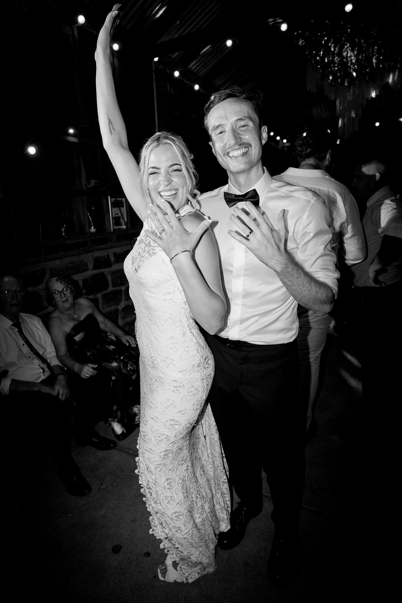 Emma throws an arm up beside George on the dance floor, in black and white.
