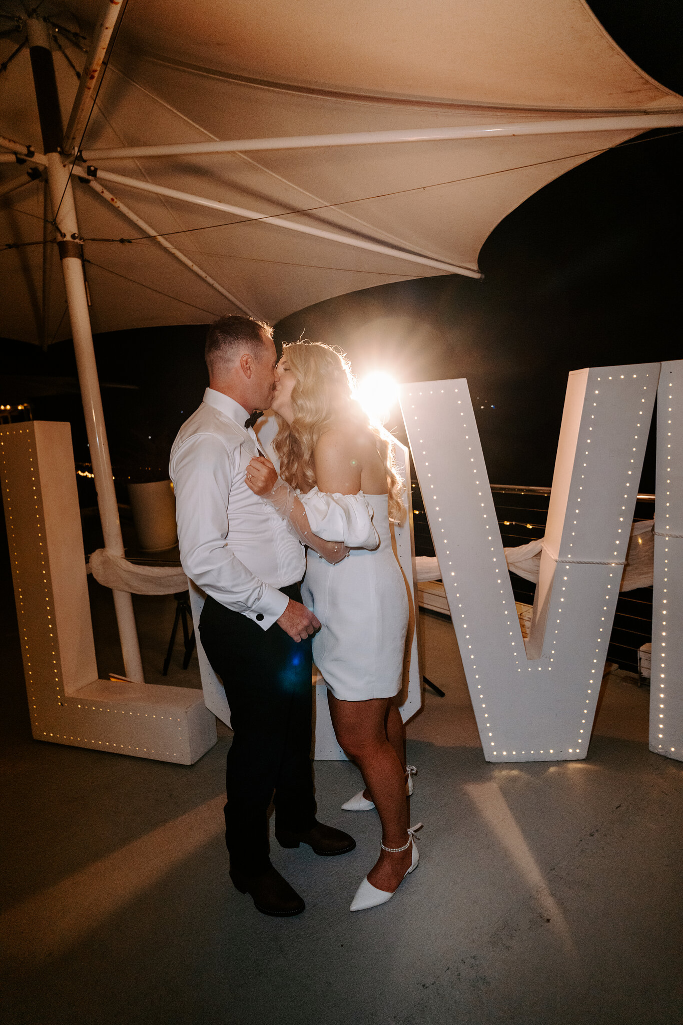 One last kiss in front of the glowing LOVE letters at the end of the night.
