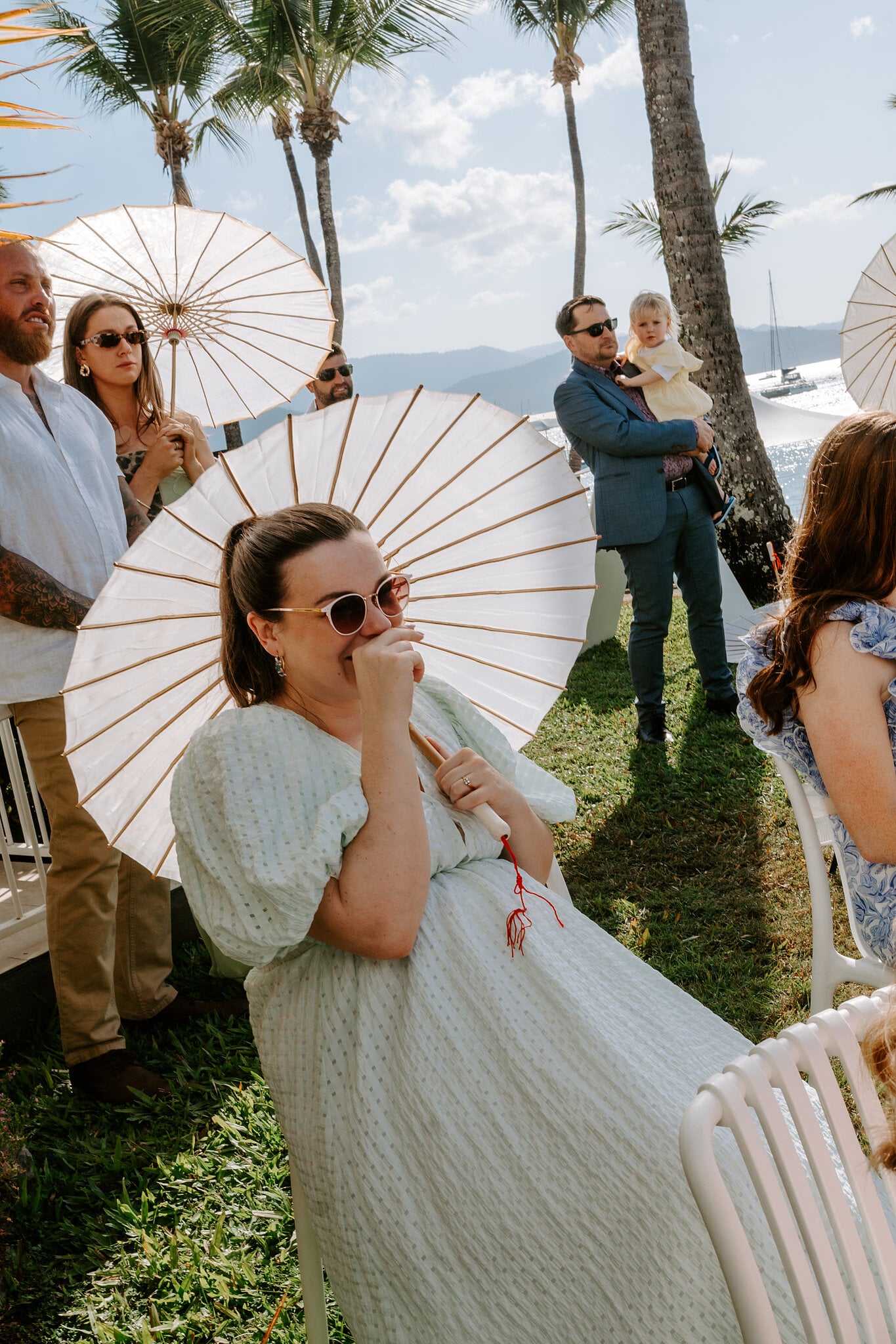 A guest under a paper parasol gets emotional during the ceremony.