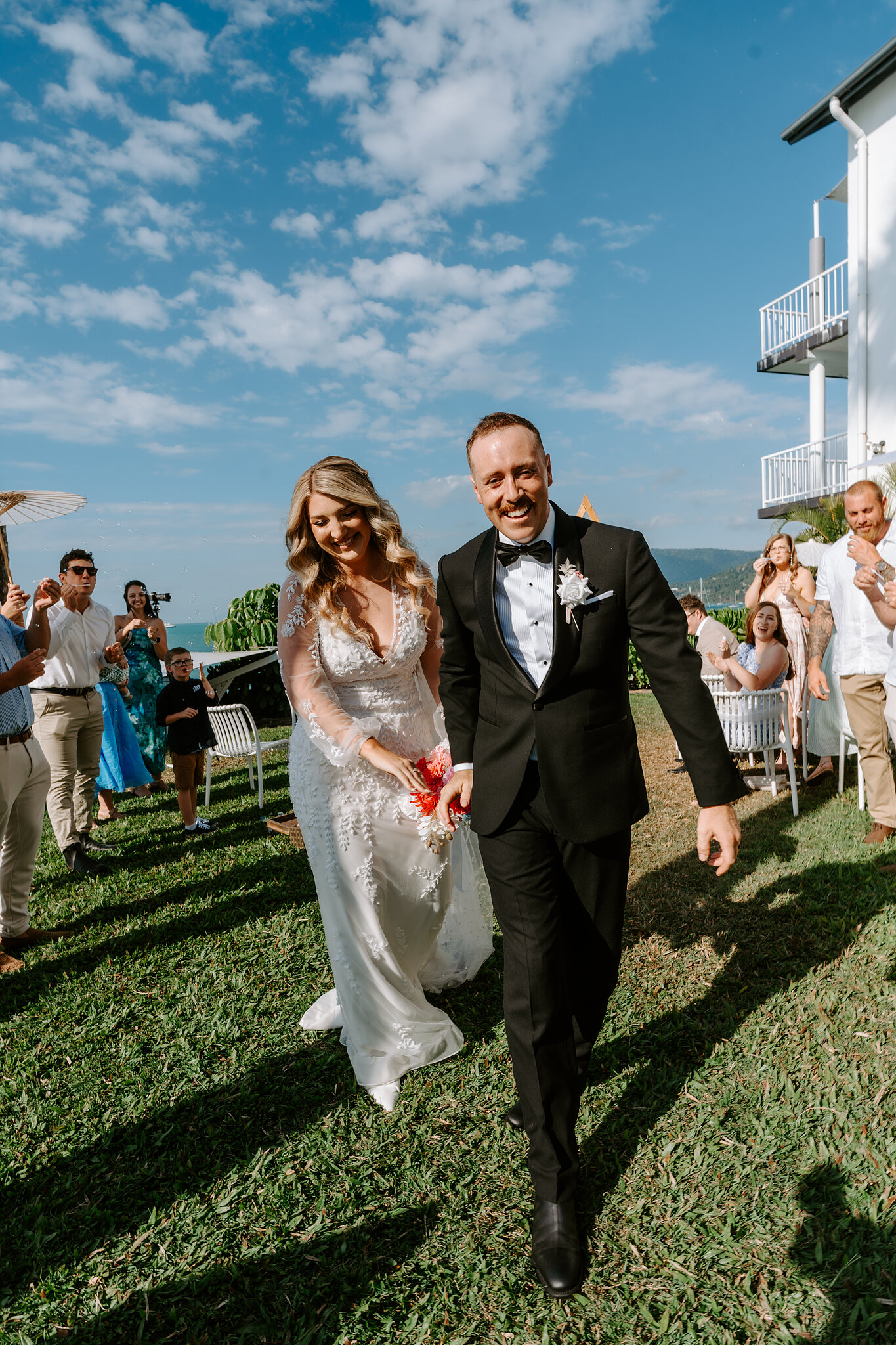 Anna and Brendan grin their way back up the lawn as husband and wife.