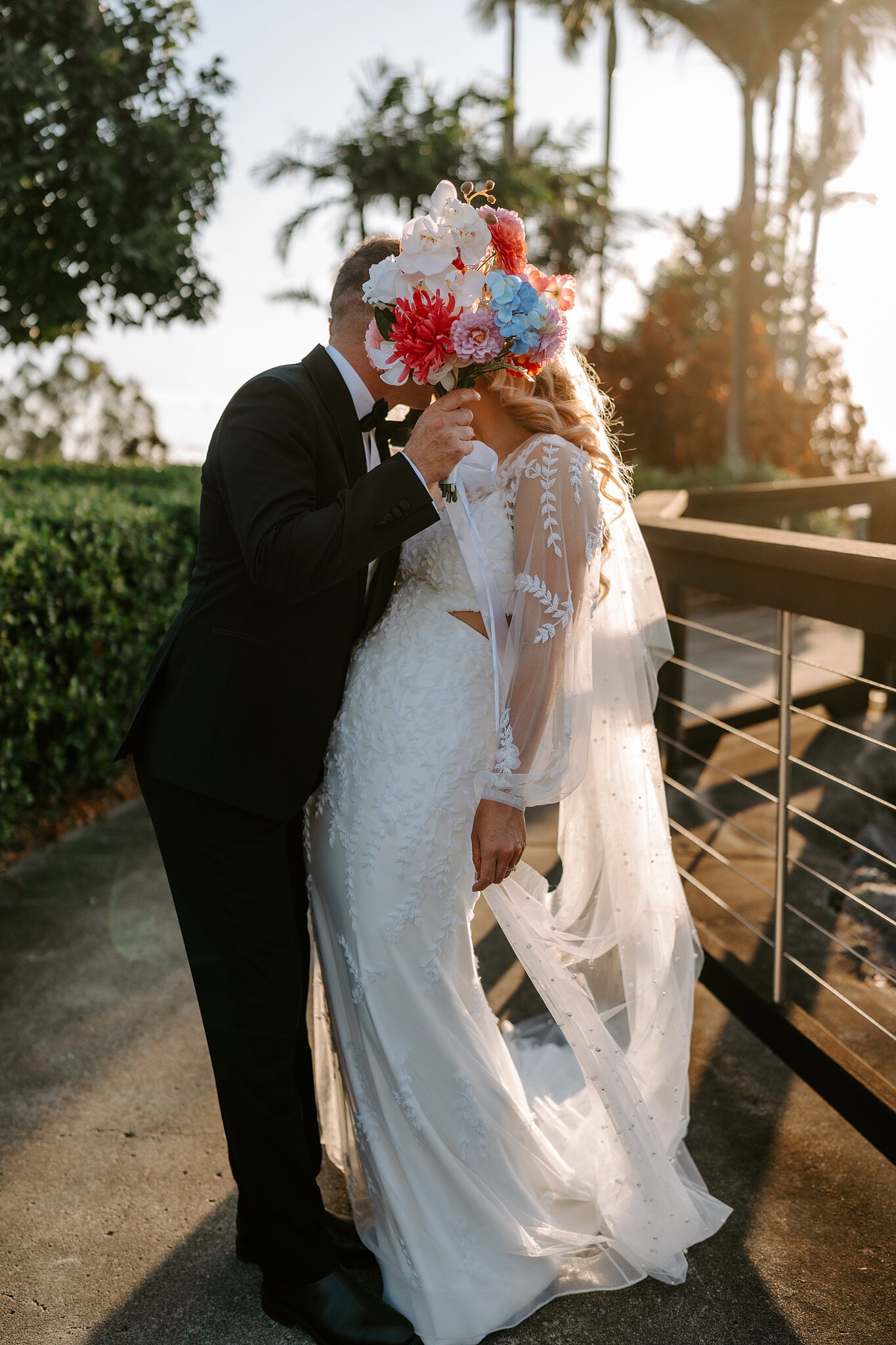 Brendan steals a kiss behind Anna’s bouquet.
