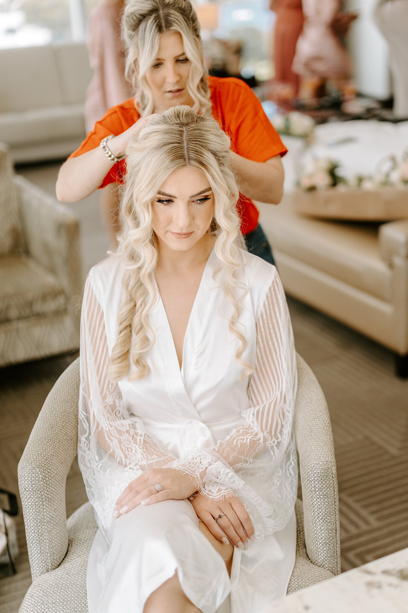 Claire sits in a lace robe as her long blonde waves are pinned into place.