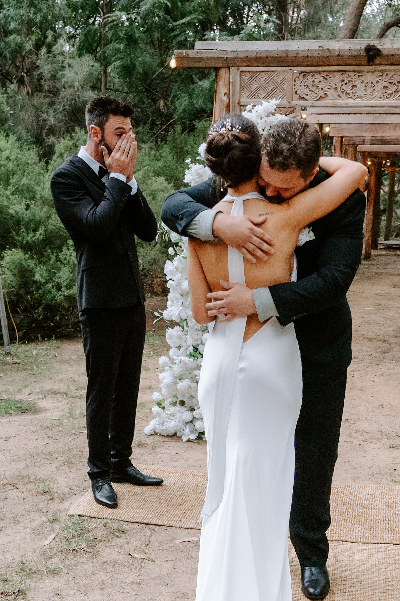 Dave covers his face, overcome, as Emma’s brother wraps her in a long hug at the aisle.