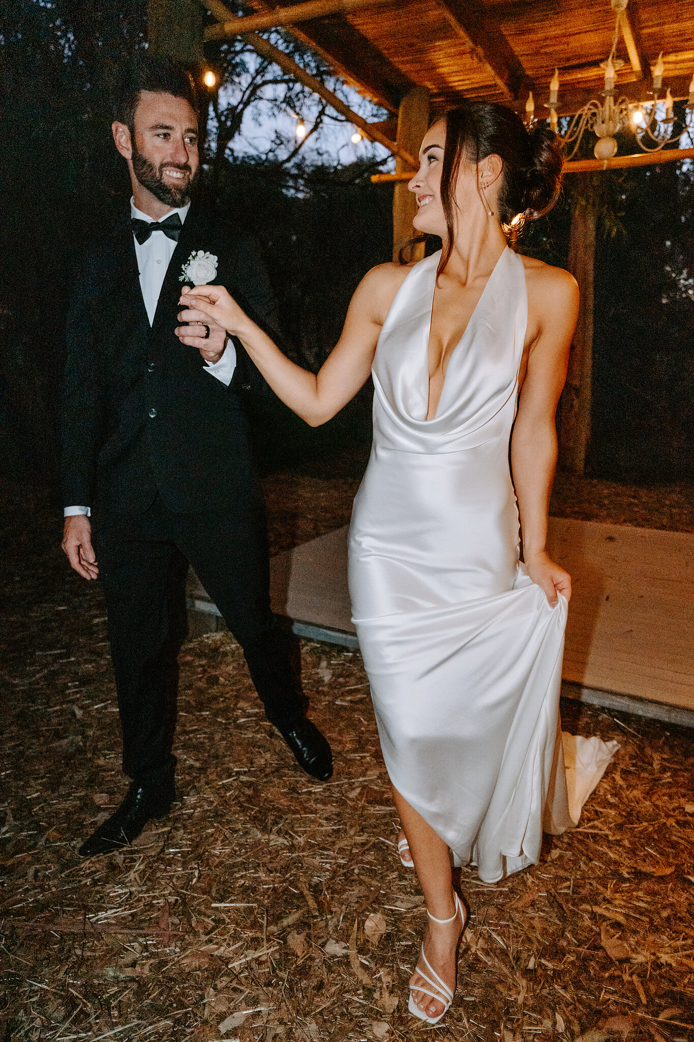 Dave holds Emma’s hand as she lifts her gown for a twirl at dusk.