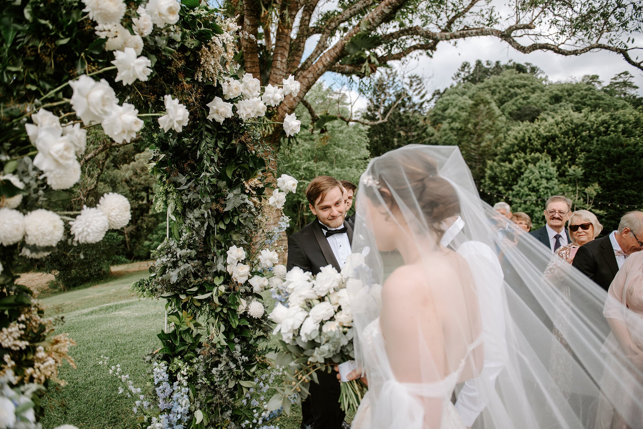 Jamie arrives at the white rose arch under the Crow’s Ash tree as Tim waits with a grin.