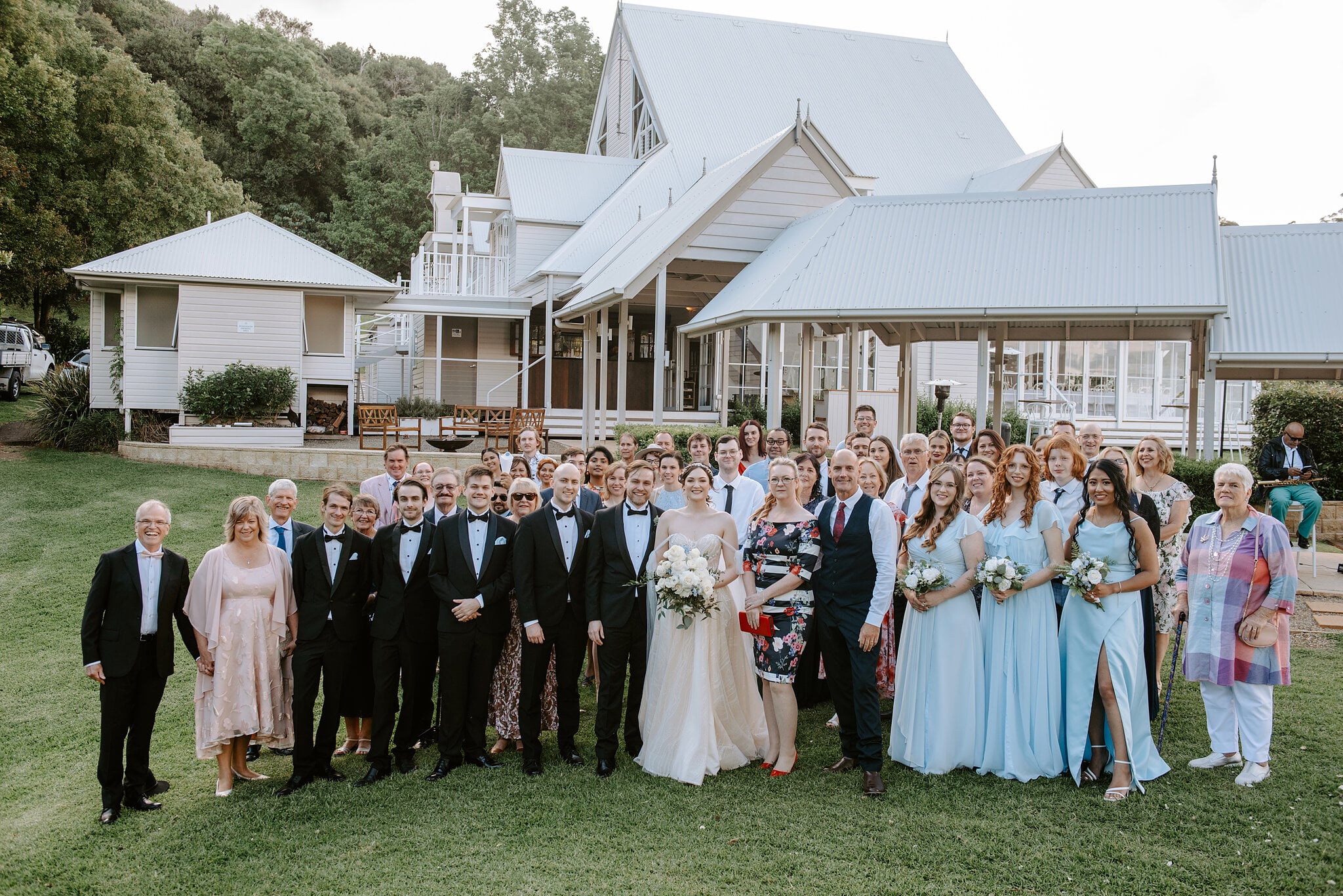 Jamie, Tim and all their guests gather on the lawn in front of the white gables of Maleny Manor.