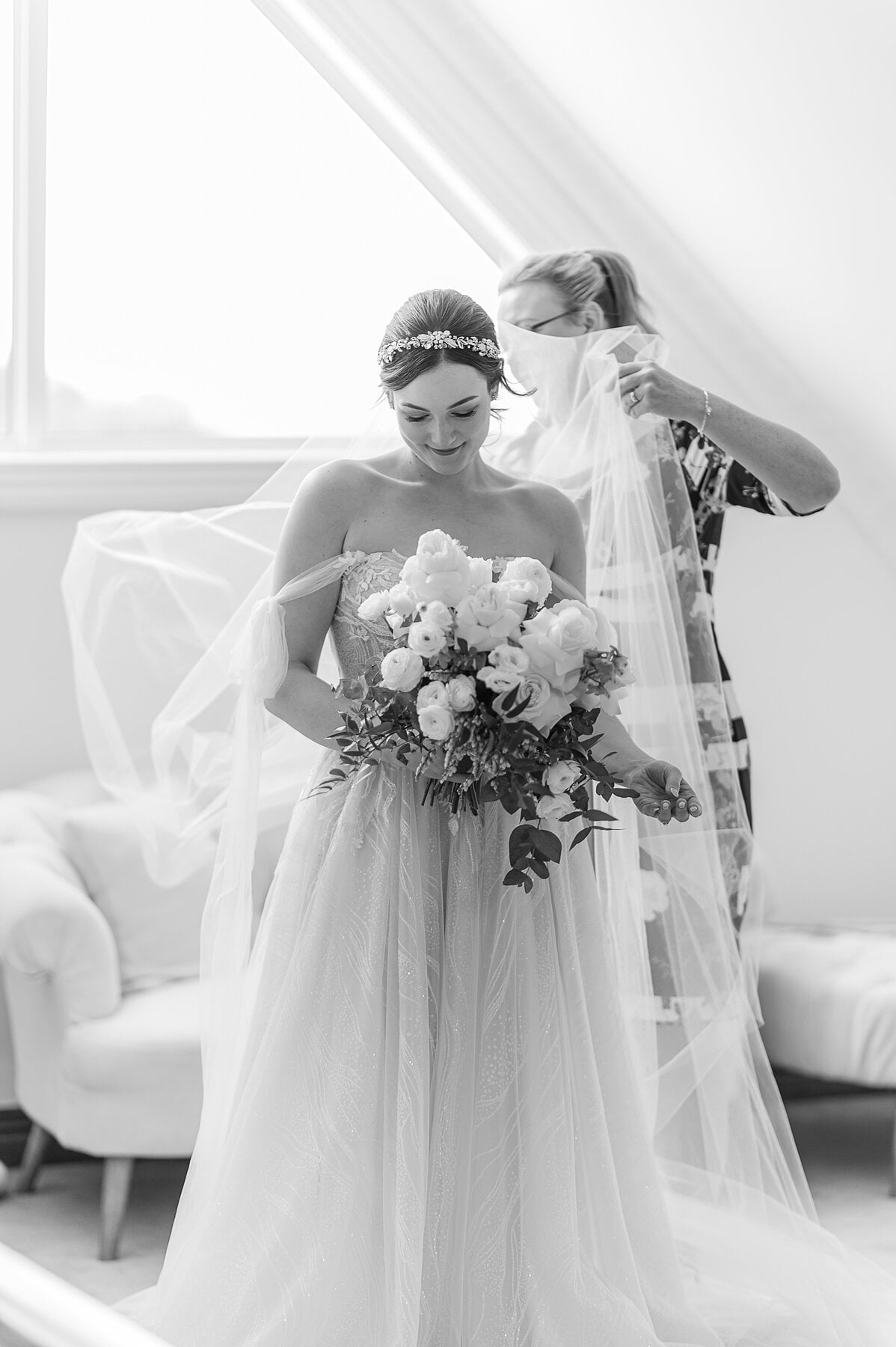 Jamie’s mum settles her veil as she looks down at her white rose bouquet.
