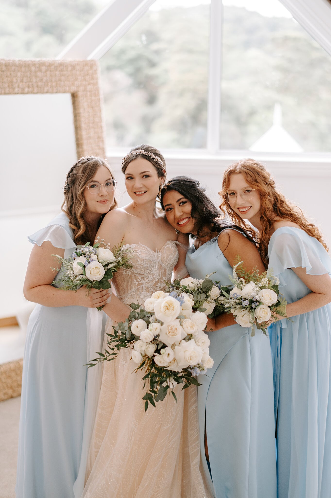 Jamie and her three bridesmaids in powder-blue dresses squeeze together with their bouquets.