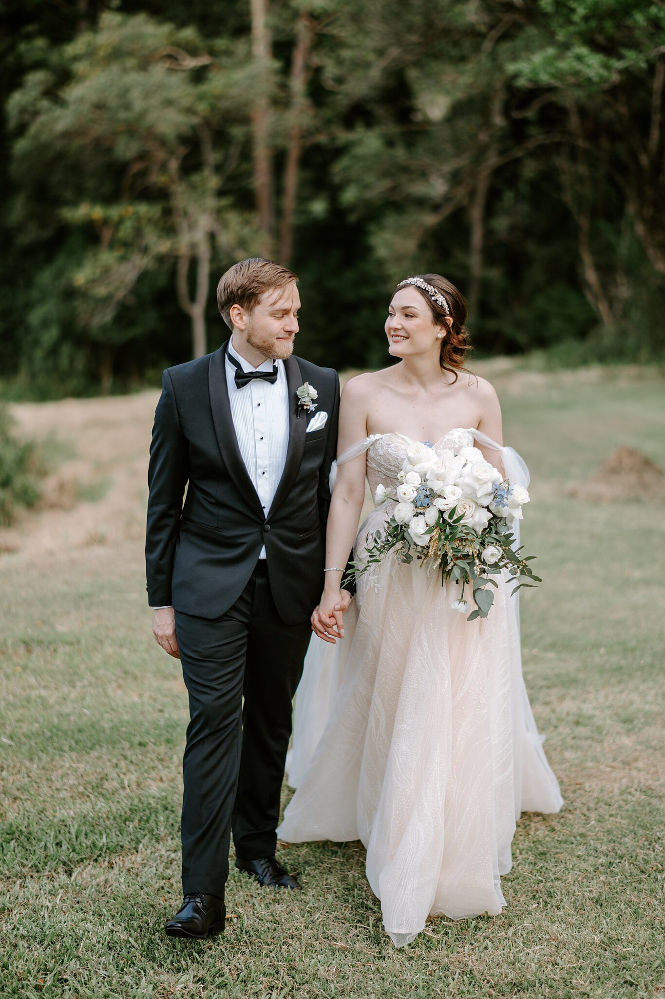 Jamie and Tim walk hand in hand along the rainforest edge at Maleny Manor.