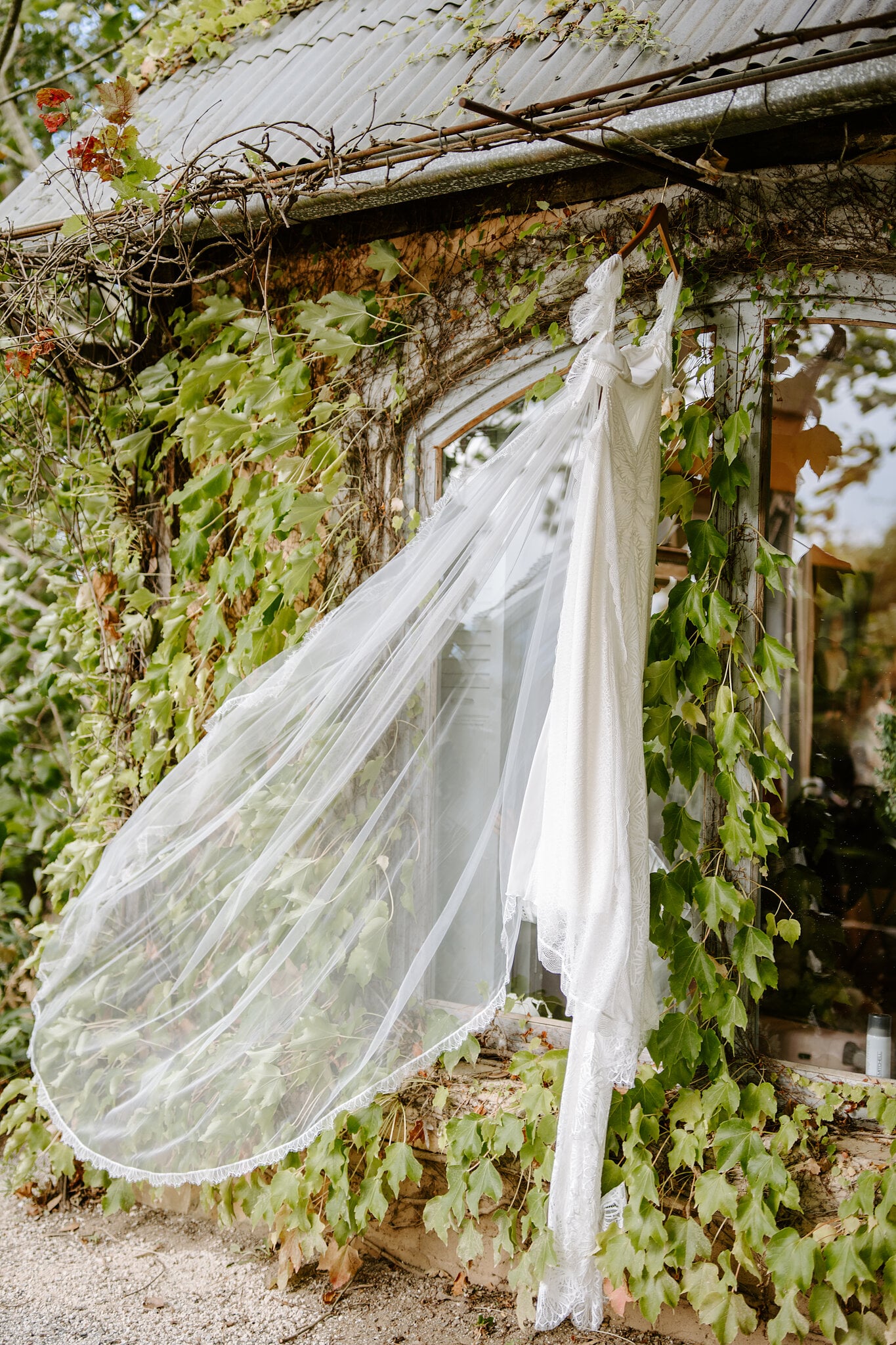 Samantha’s gown and veil hang from the ivy-covered cottage window at Mont du Soleil.