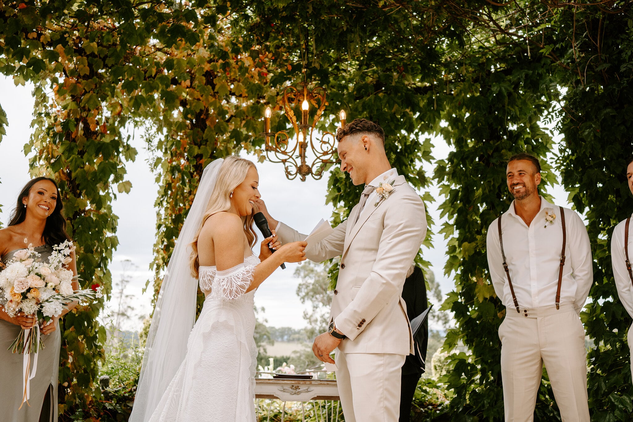 Samantha reads her vows into the microphone as Harrison grins beside her.