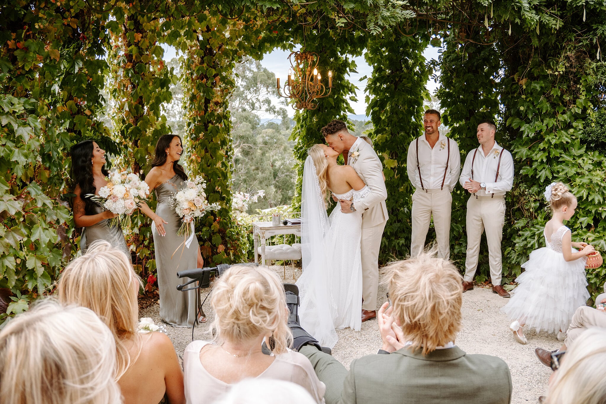 The first kiss under the vines at Mont du Soleil as the flower girl looks on.