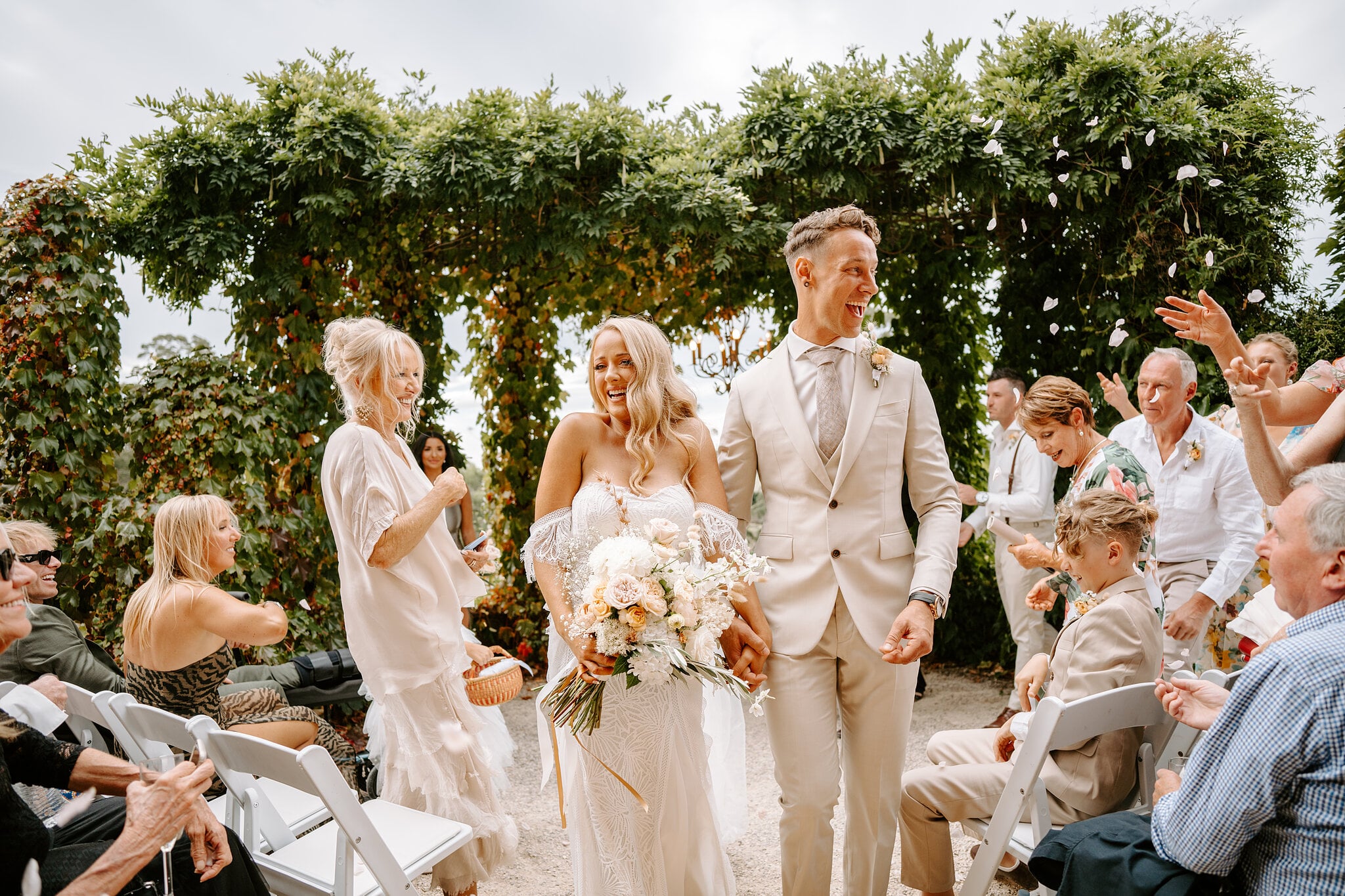 Petals fly as Samantha and Harrison walk back down the aisle laughing.