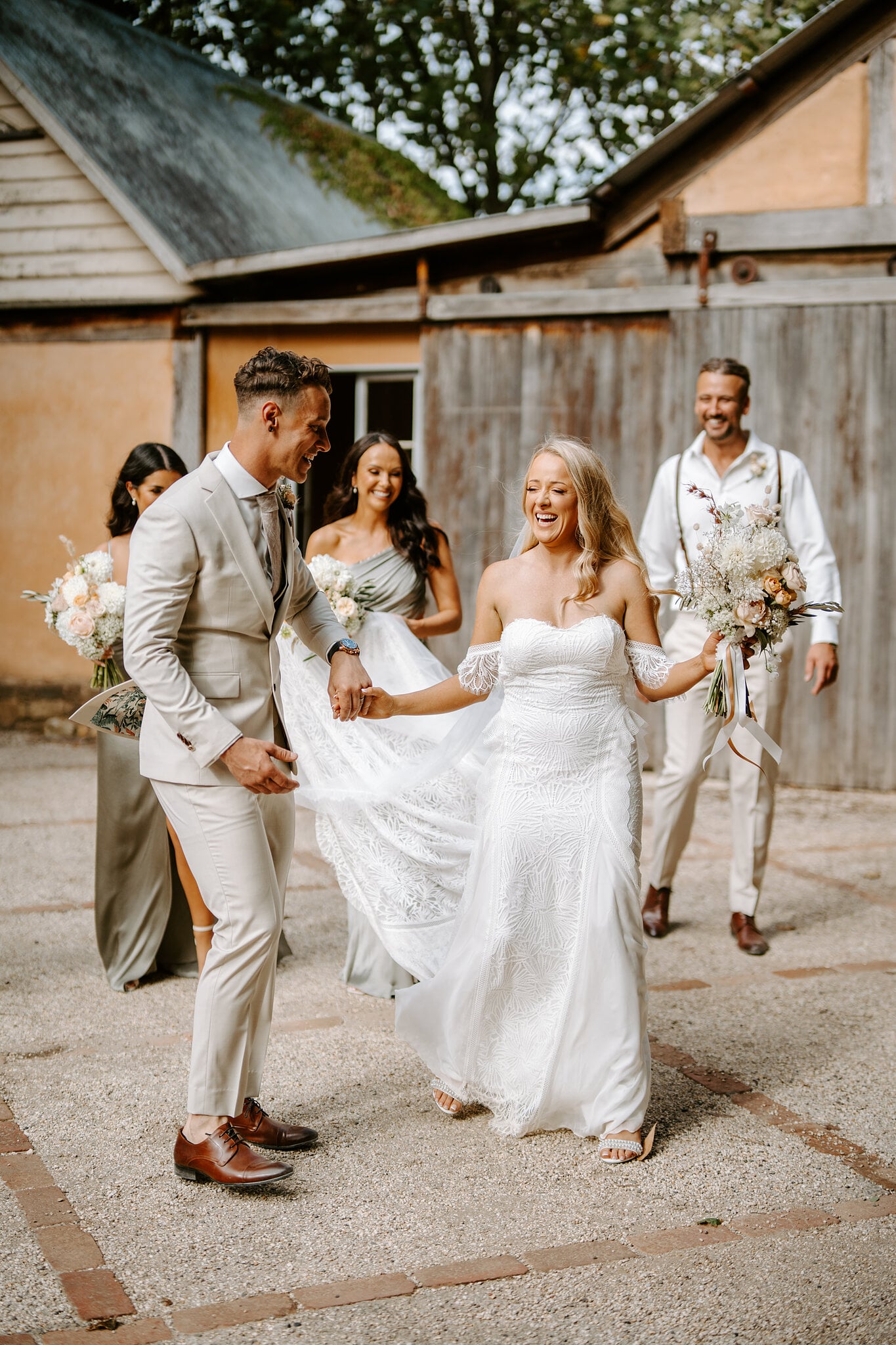 Harrison spins Samantha in the courtyard as the bridesmaids and groomsmen laugh.