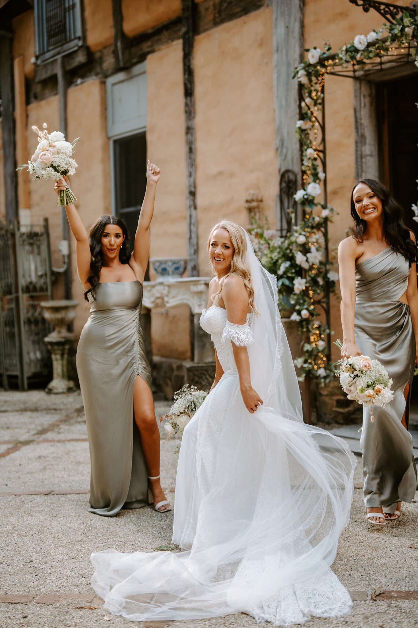 Samantha twirls between her cheering bridesmaids beside a rose-covered arch at Mont du Soleil.