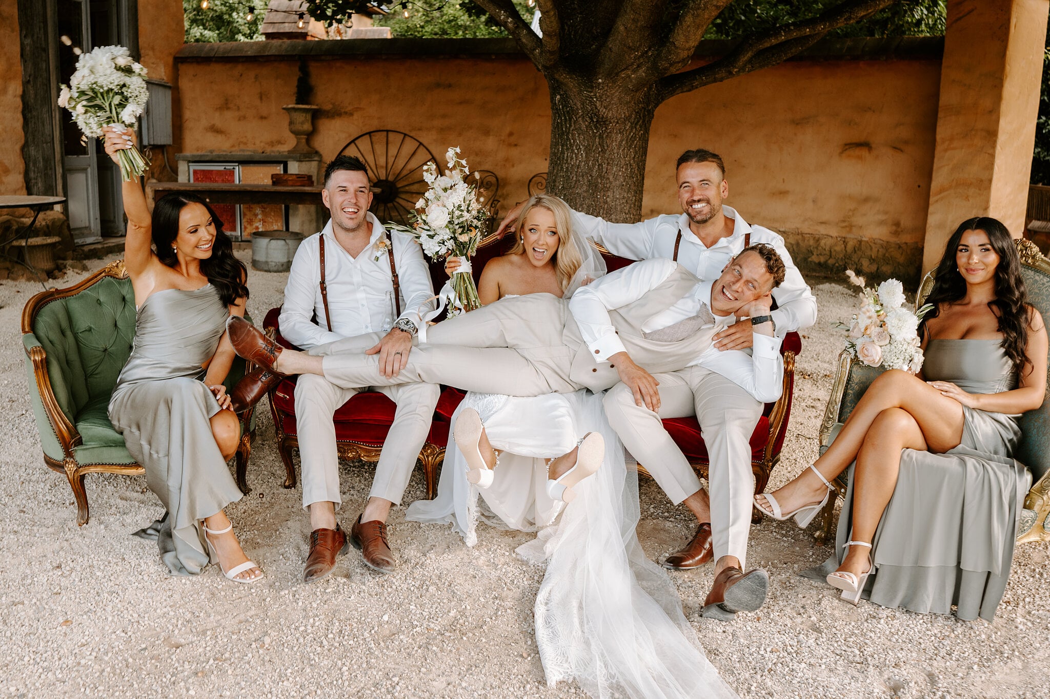The bridal party piles onto vintage velvet sofas with Harrison stretched across their laps.