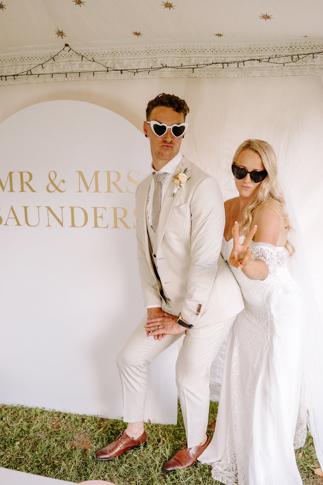 Samantha and Harrison pose in heart-shaped sunglasses at the photo wall.