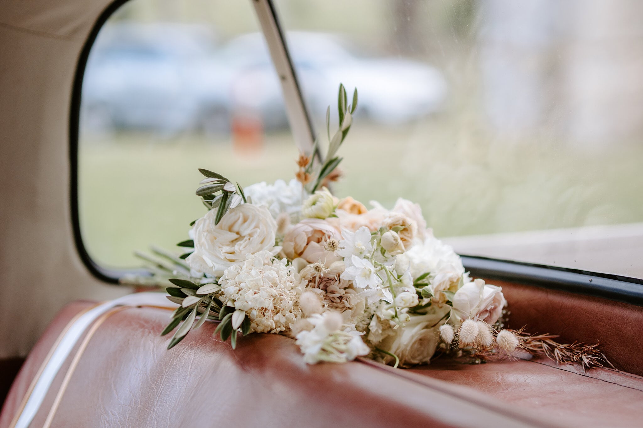 Samantha’s bouquet rests on the red leather seat of the vintage ute.