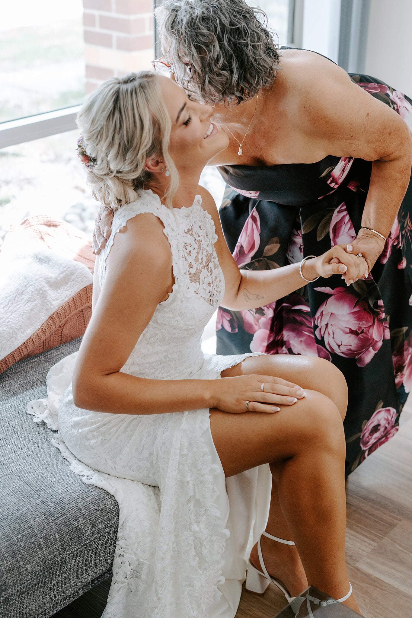 Emma’s mum kisses her head as they hold hands, Emma already in her lace gown.