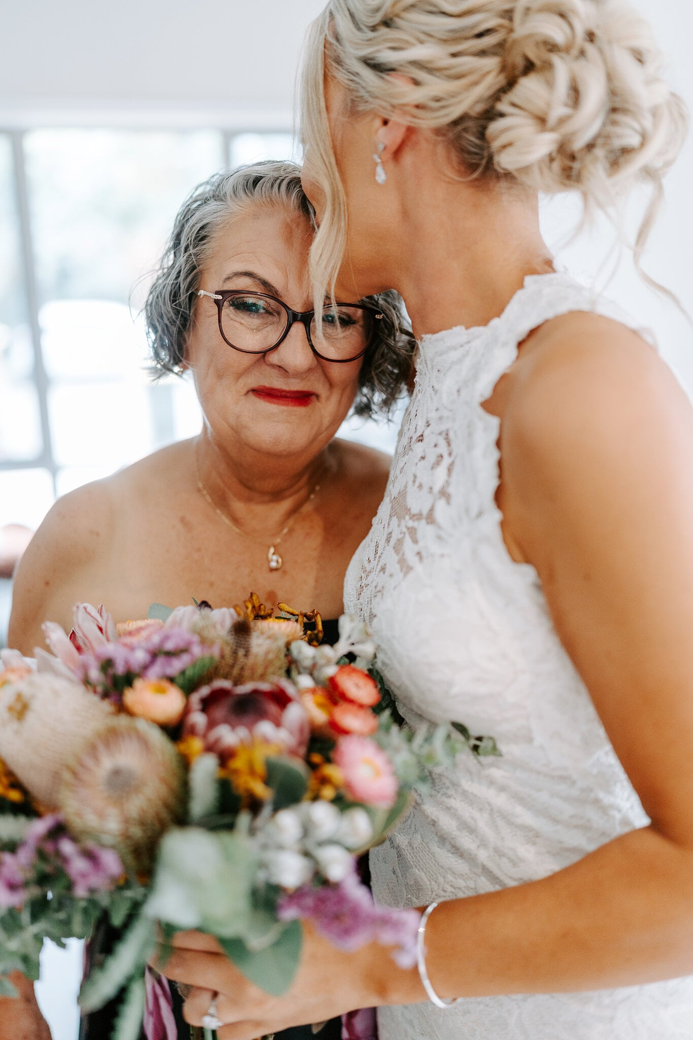 Emma and her mum share a quiet moment over a bouquet of proteas and native blooms.