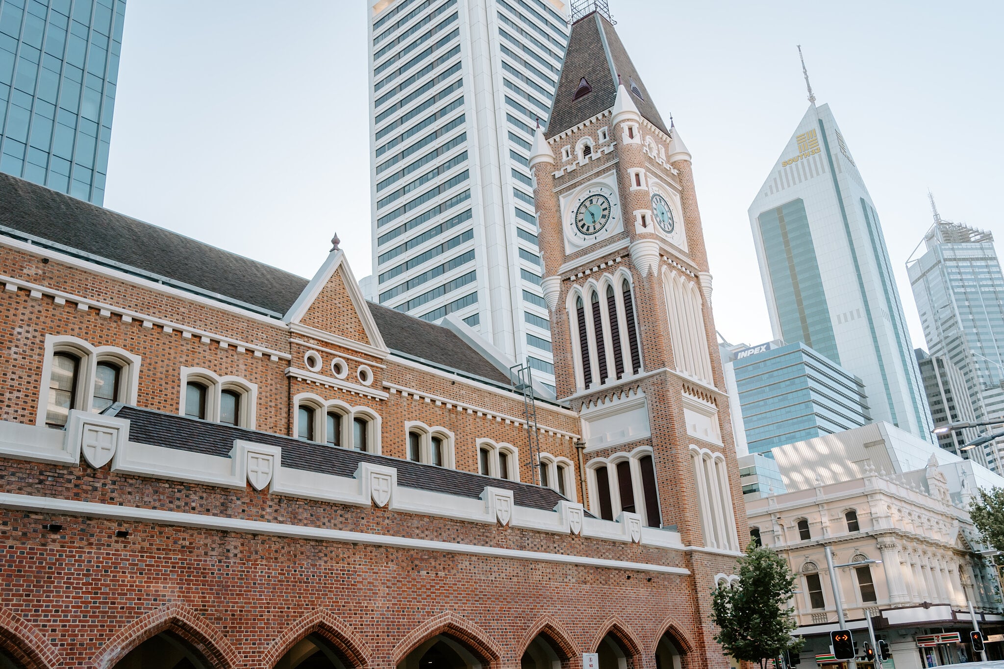 The red brick clock tower of Perth Town Hall against the glass towers of the Perth CBD.