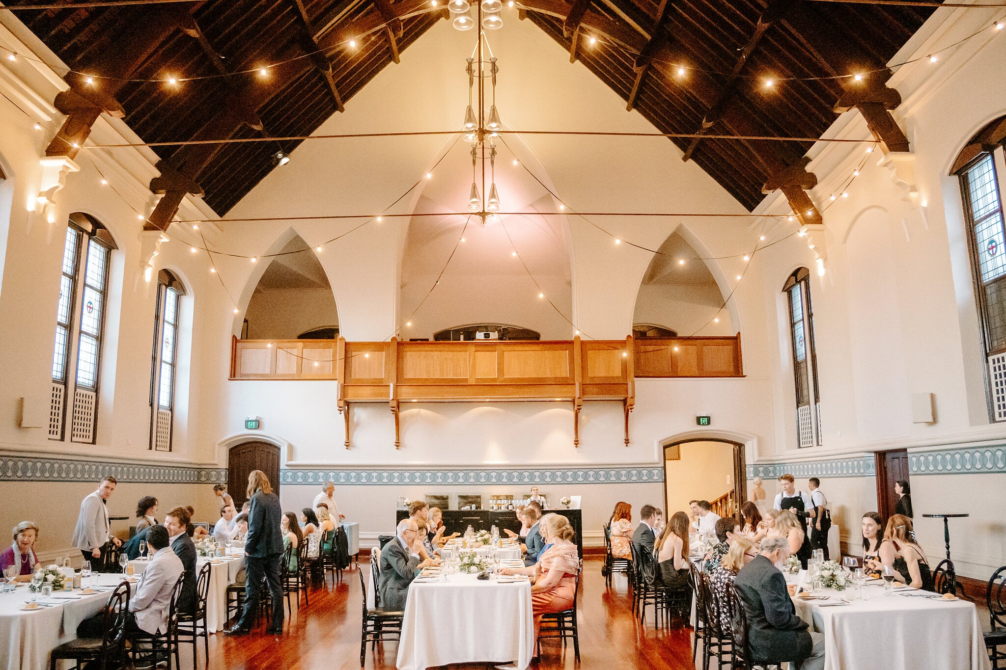 Guests at dinner beneath the timber roof trusses and gallery of the Perth Town Hall Main Hall.