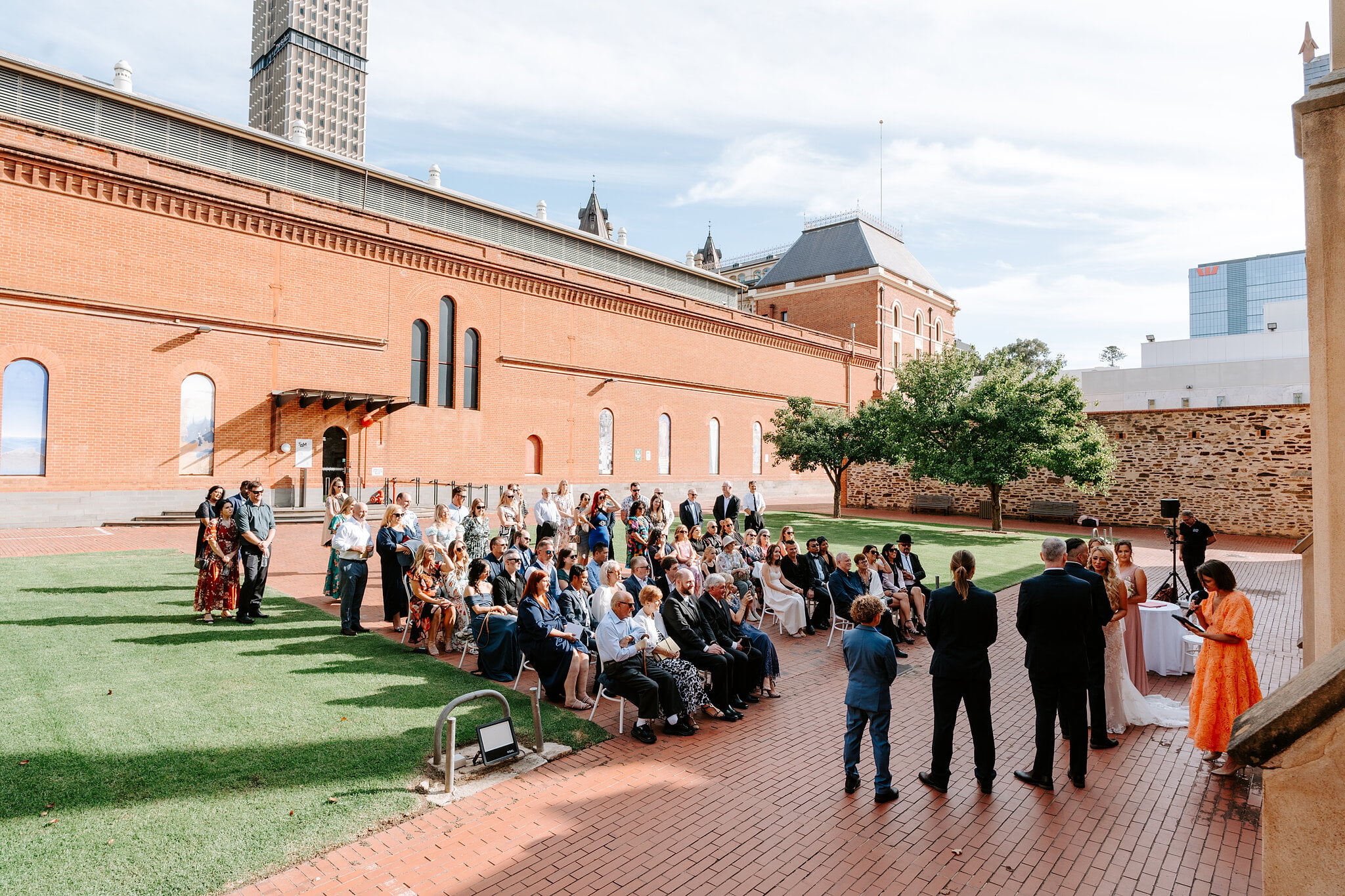 The ceremony on the red-brick path beside the museum’s long red-brick wing, guests gathered on the lawn.