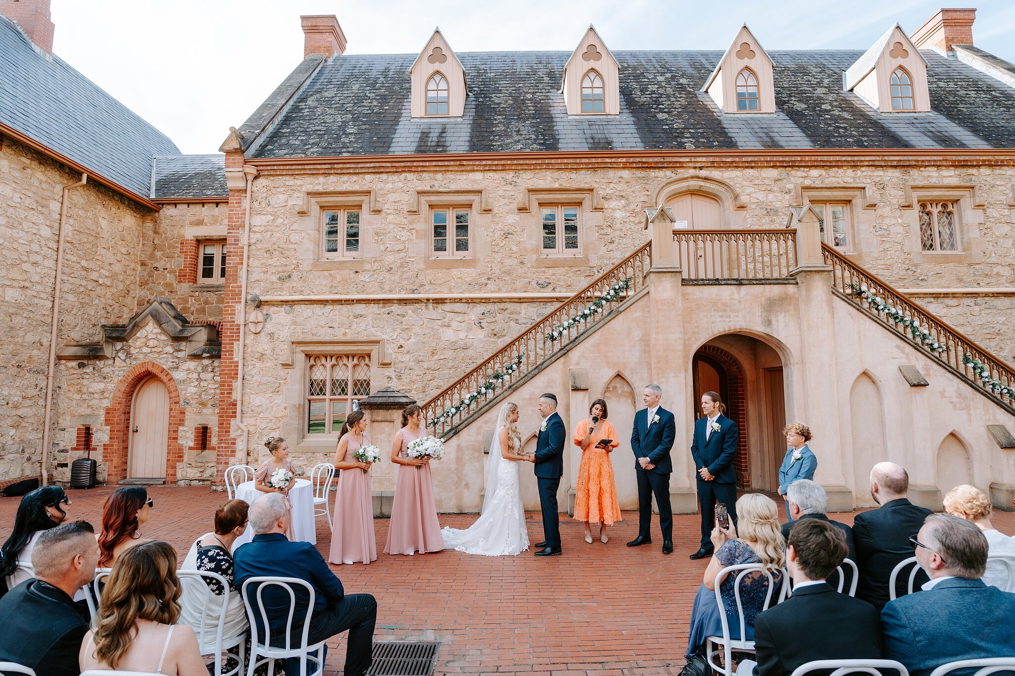 Sarah and Joe face each other under the Armoury’s twin staircase as the celebrant leads the ceremony.