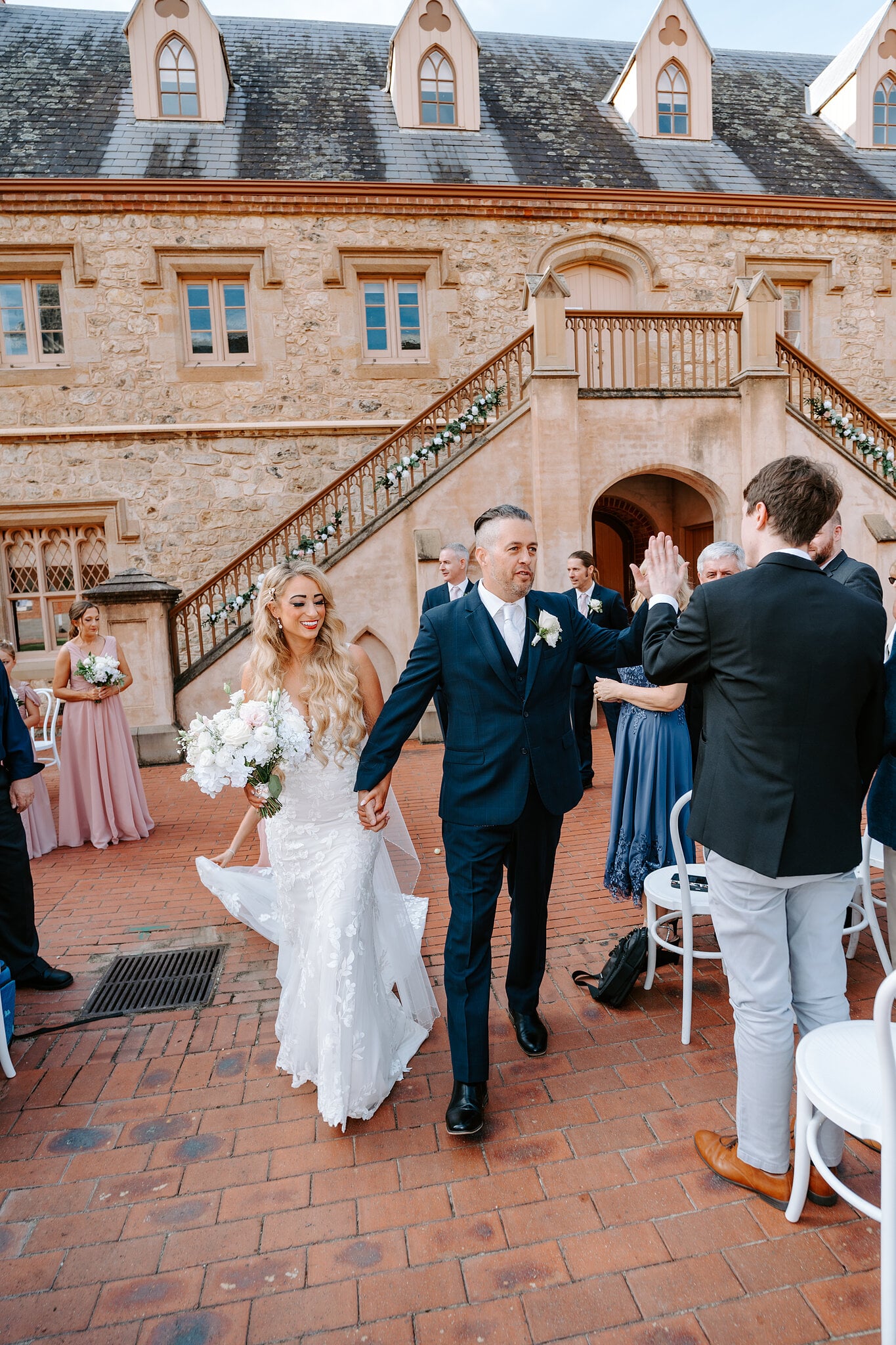 Joe high-fives a guest as he and Sarah walk back down the aisle.